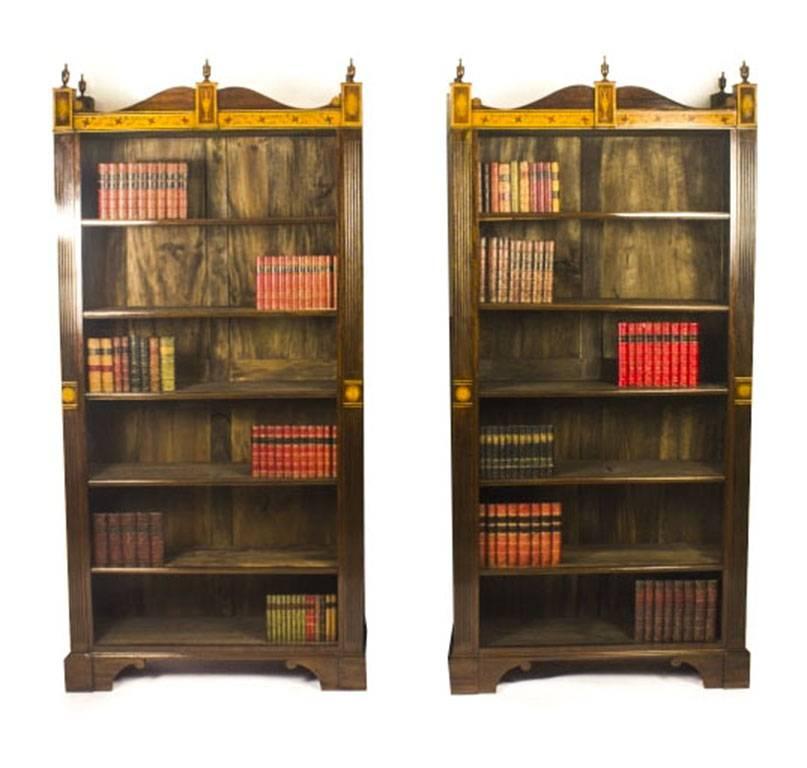 This is a beautiful vintage pair of mahogany open bookcases in Sheraton style with adjustable shelves, dating from the mid-20th century.

They are made from mahogany with beautiful satinwood inlaid marquetry decoration with crossbanding, they have