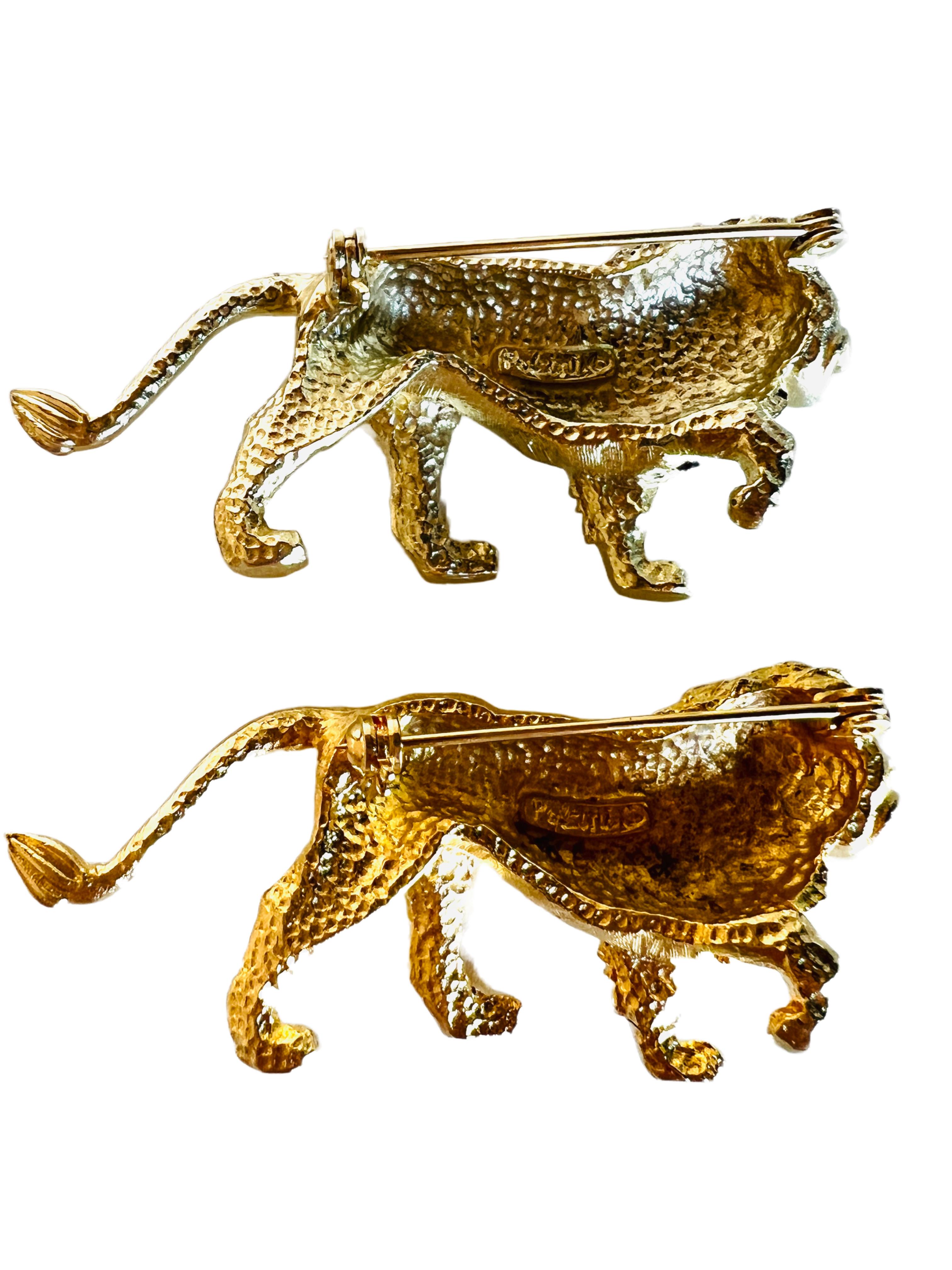 Fabulous pair of lion brooches by designer Polcini featuring gold plated metal and a rhinestone eye. 

Size: 2-1/2