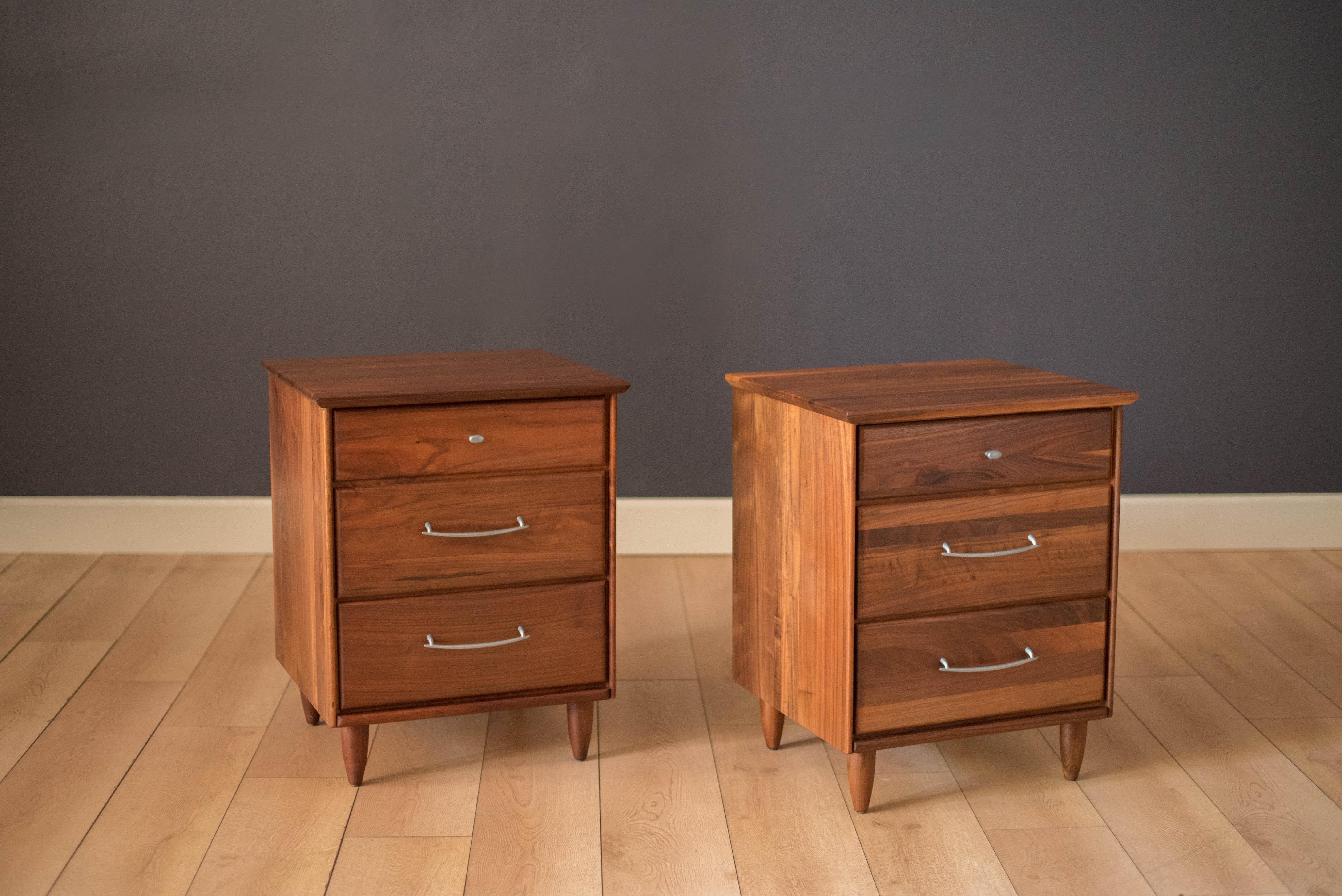 Mid-Century Modern pair of nightstands or bedside tables by ACE-HI Furniture, California. This set is made of solid planked walnut and includes three storage drawers with pewter handles. Price is for the pair.