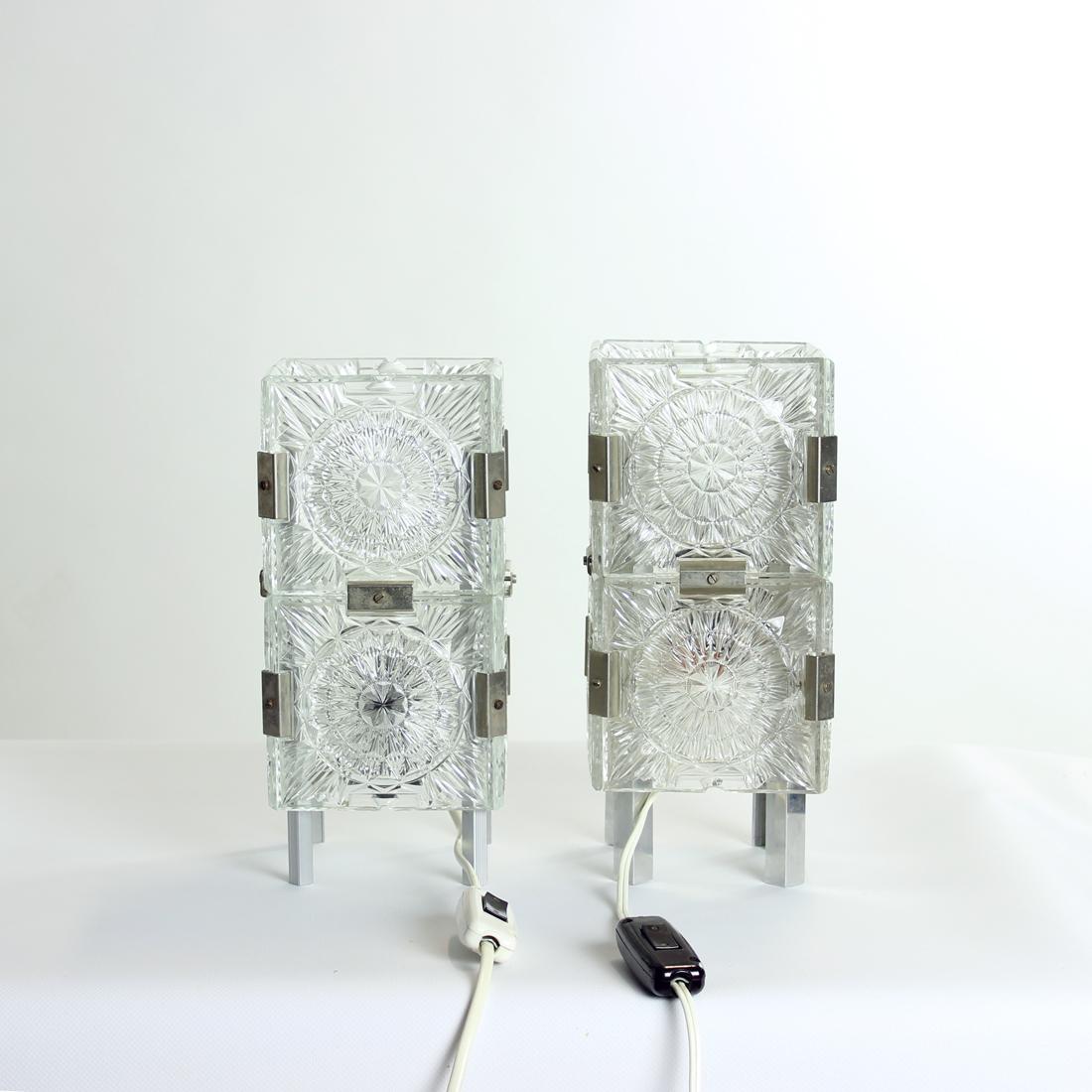 Beautiful set of two table lamps produced by Kamenicky Senov company in Czechoslovakia in 1970s. The lights by this company always combine a high quality of crystal glass panels with a beautiful design. These two lamps are standing on a aluminum