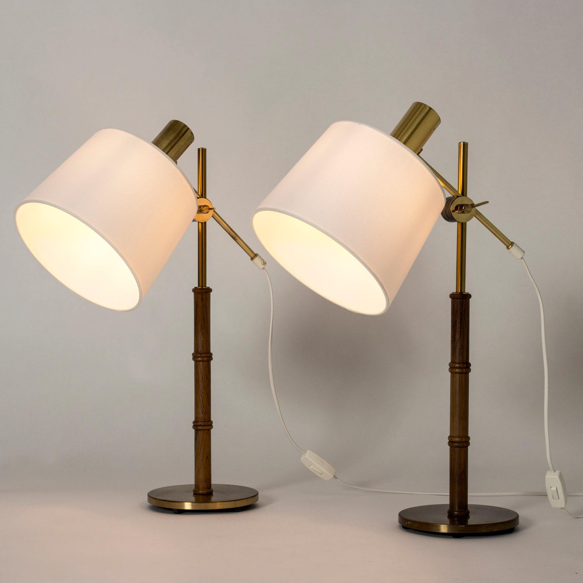 Pair of elegant table or desk lamps from Falkenbergs Belysning, made from brass with rosewood stems. Wood carved into a bamboo-stem form. Adjustable height and angle of the shades.