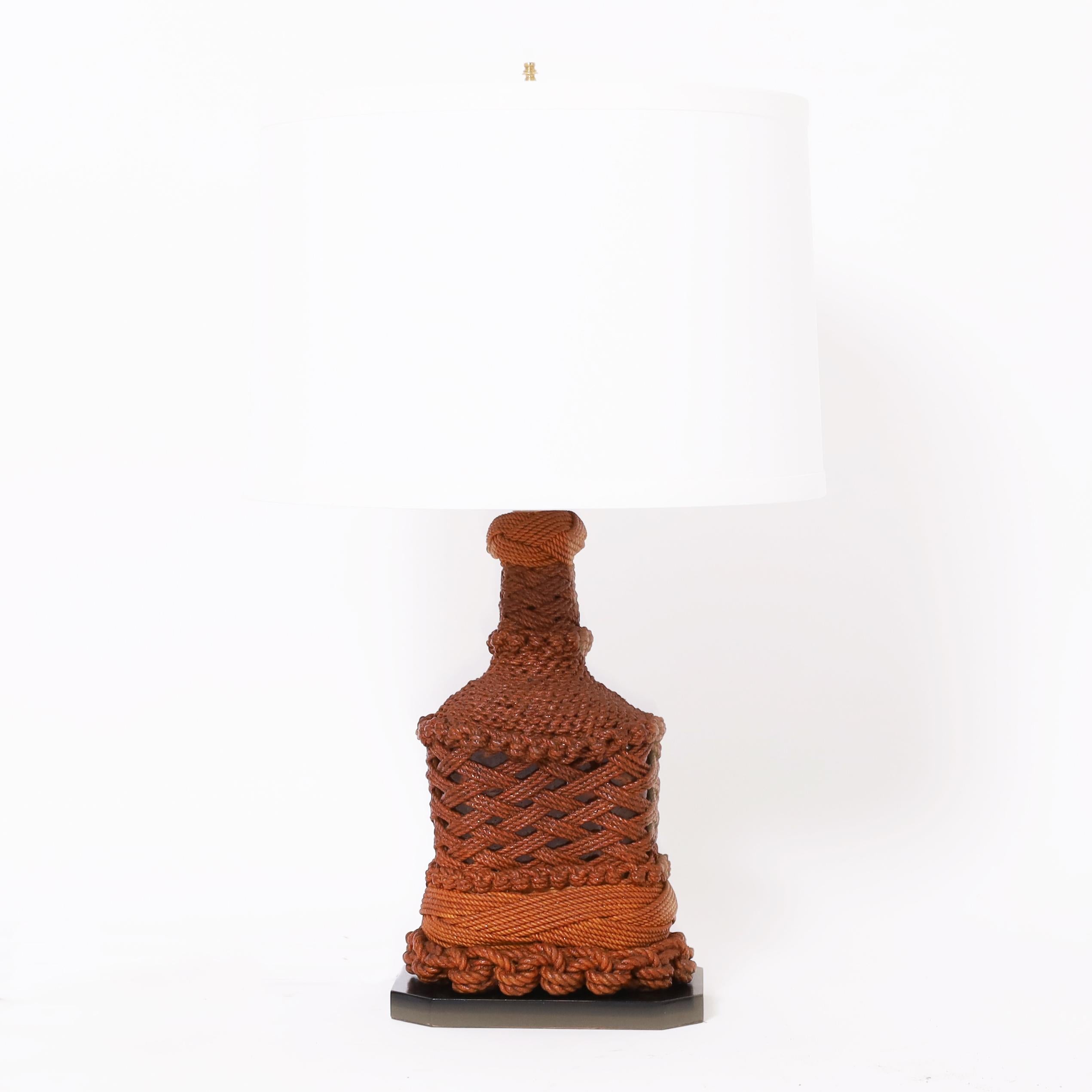 Rare et inhabituelle paire de lampes de table fabriquées à la main avec des bouteilles enveloppées de ficelle et de corde dans plusieurs motifs ambitieux, puis vernies et présentées sur des bases en bois. 
