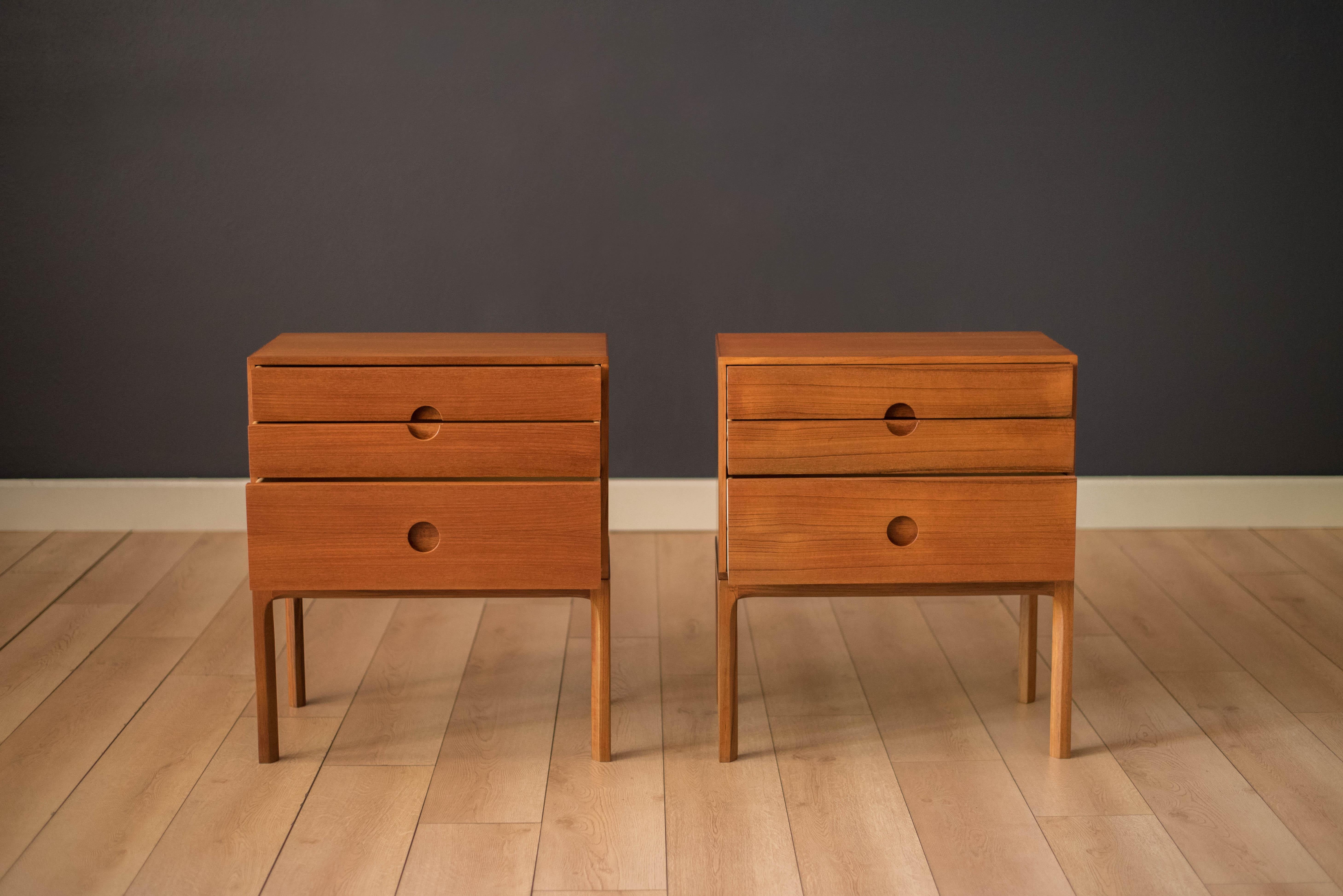 Mid-Century Modern matching pair of teak bedside tables designed by Kai Kristiansen for Aksel Kjersgaard, Denmark. This set features sleek circular recessed pulls that open three dovetail storage drawers. Each case is designed with quality