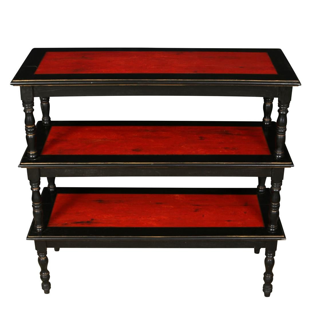 A pair of vintage three tiered etageres painted black with distressed red shelves and turned legs.