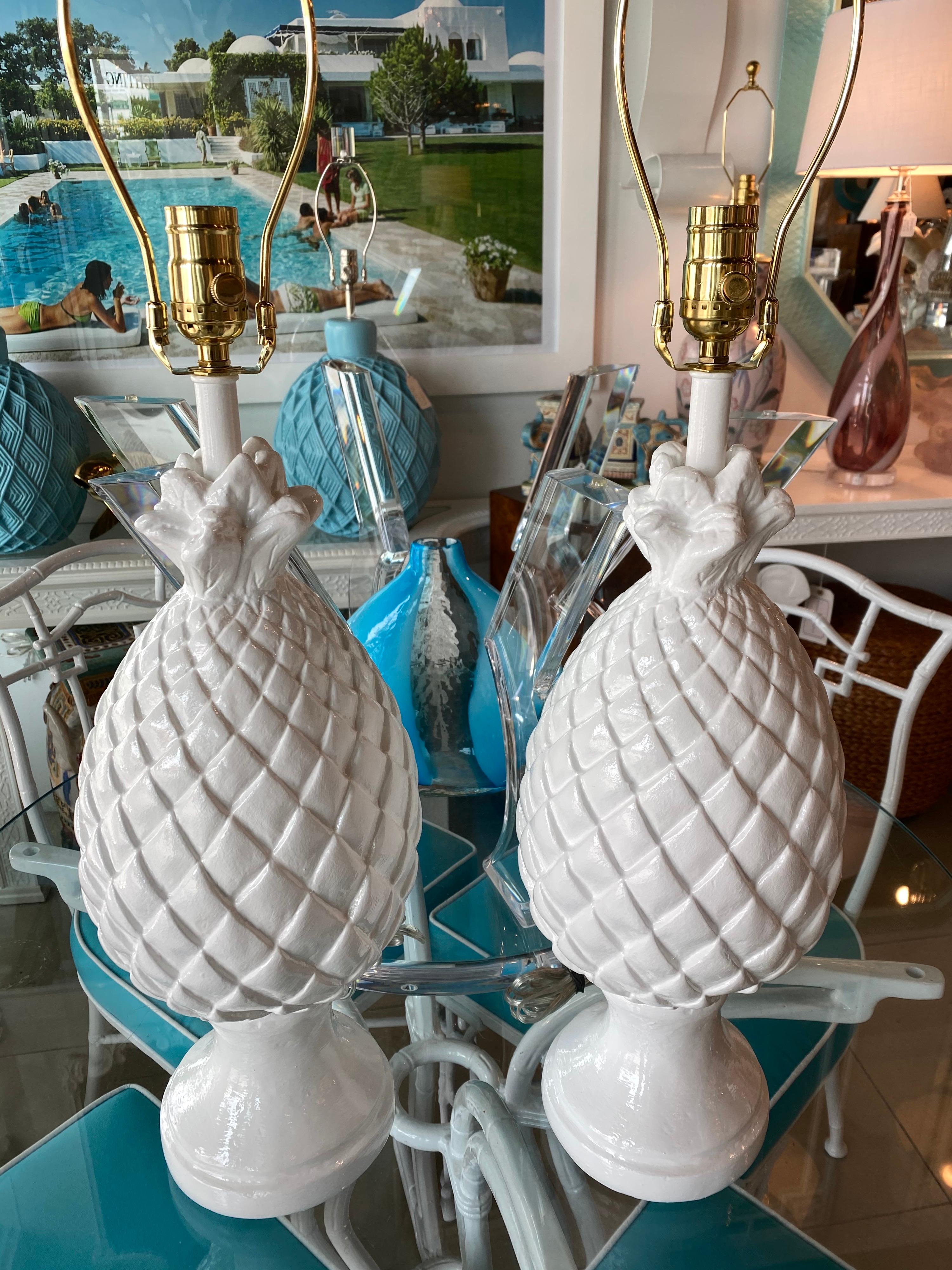 Lovely pair of vintage white plaster pineapple table lamps. These have been newly wired with all new brass hardware, 3 way sockets. Measures: 28.5 H to finials, 22 H to top of sockets.