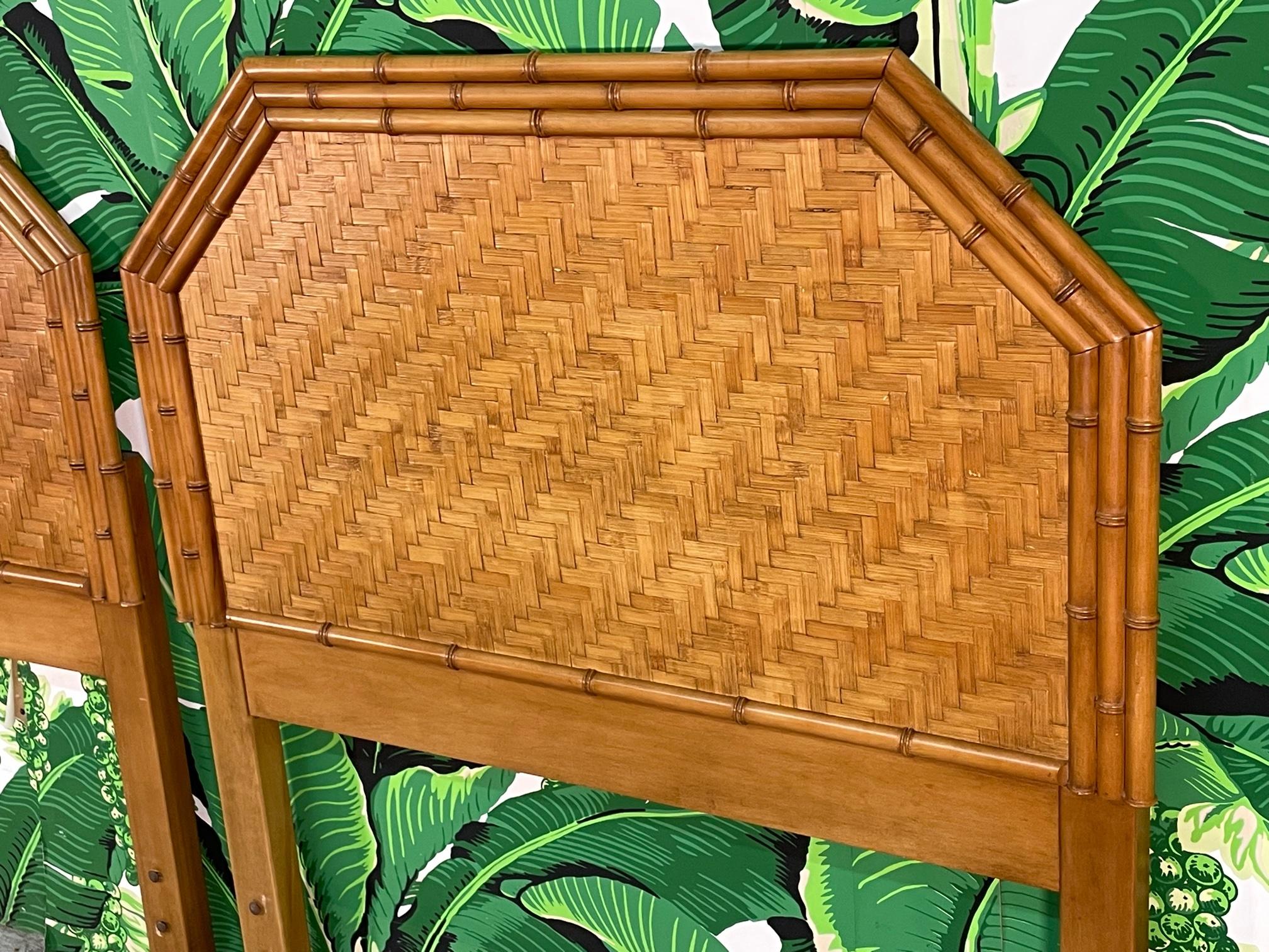 Vintage pair of twin headboards feature faux bamboo detailing and a complete veneer of woven rattan basket weave in a herringbone pattern. The unique rattan veneer gives a look of parquet. Reminiscent of designs by Bielecky Brothers. Warm, rich tone