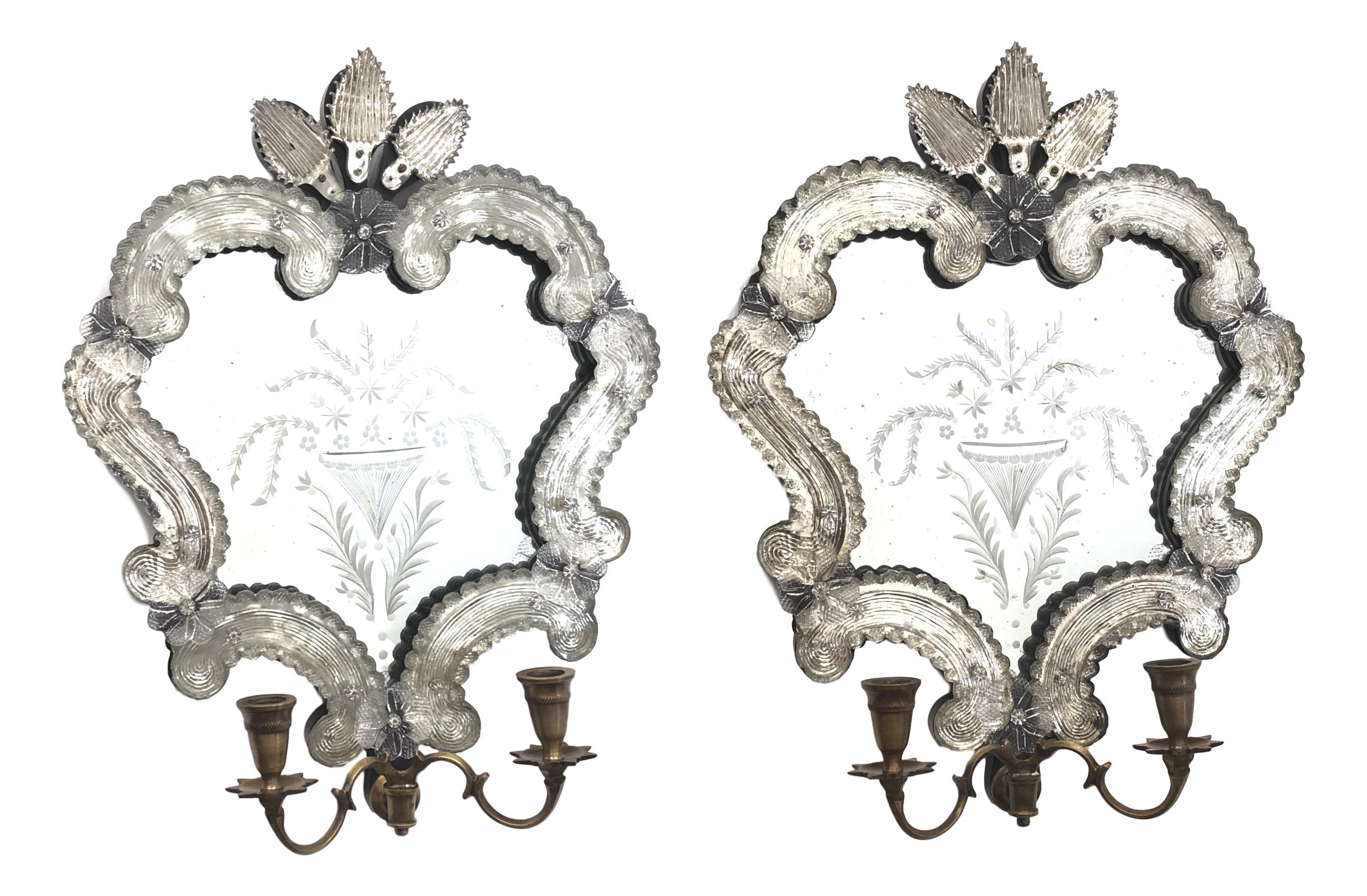 Vintage Italian Rococo Revival mirror wall sconces hand blown in clear Murano glass with decorative details, antiqued patina on mirror, mounted on wood back frame. 2 candles each sconce. With minor signs of wear as expected with age and use. A nice