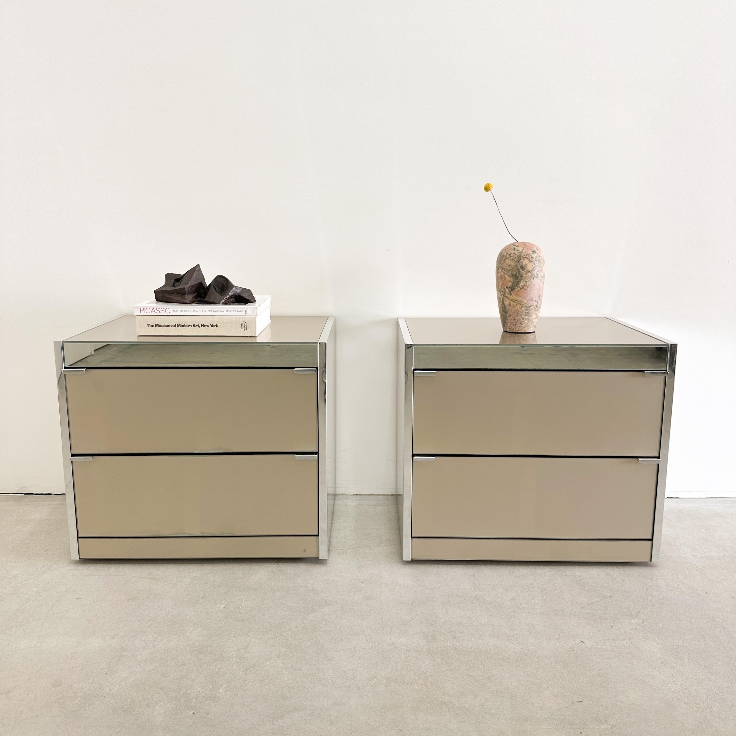 Pair of Vintage Ello O.B Solie Glass And Chrome Nightstands.

The nightstands are made of taupe glass and chrome. They have 2 drawers. The drawers are clean and open and shut easily.

Color: Light Taupe & Chrome 

Measurements:
Length: 25