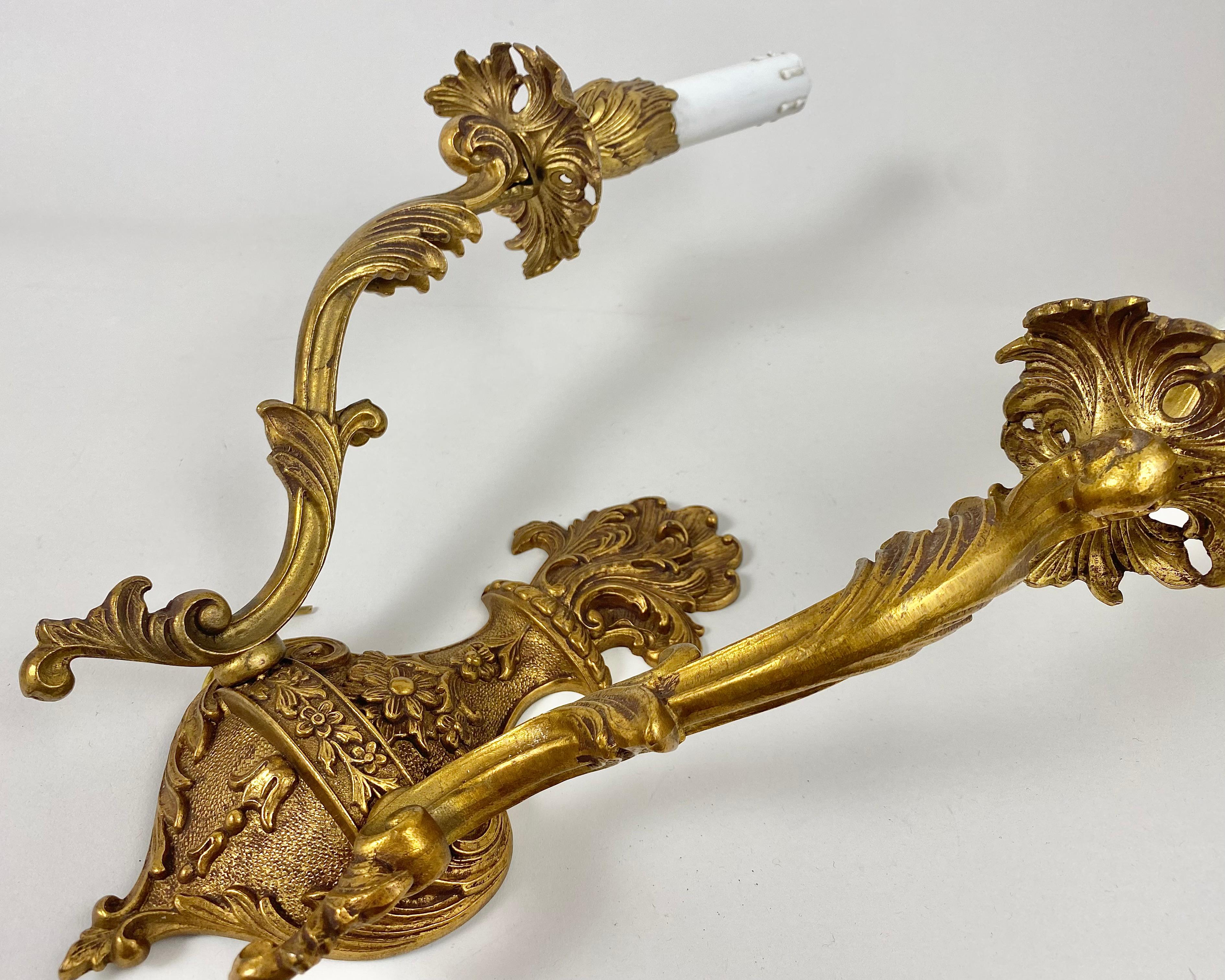 Un'elegante coppia di applique in stile Luigi XVI, circa 1960, in bronzo finemente cesellato e dorato con bracci a due luci.

Candele opaline finte.

Prodotto in Francia, anni '60.

Sono traforati e decorati con avvolgimenti, foglie d'acanto e