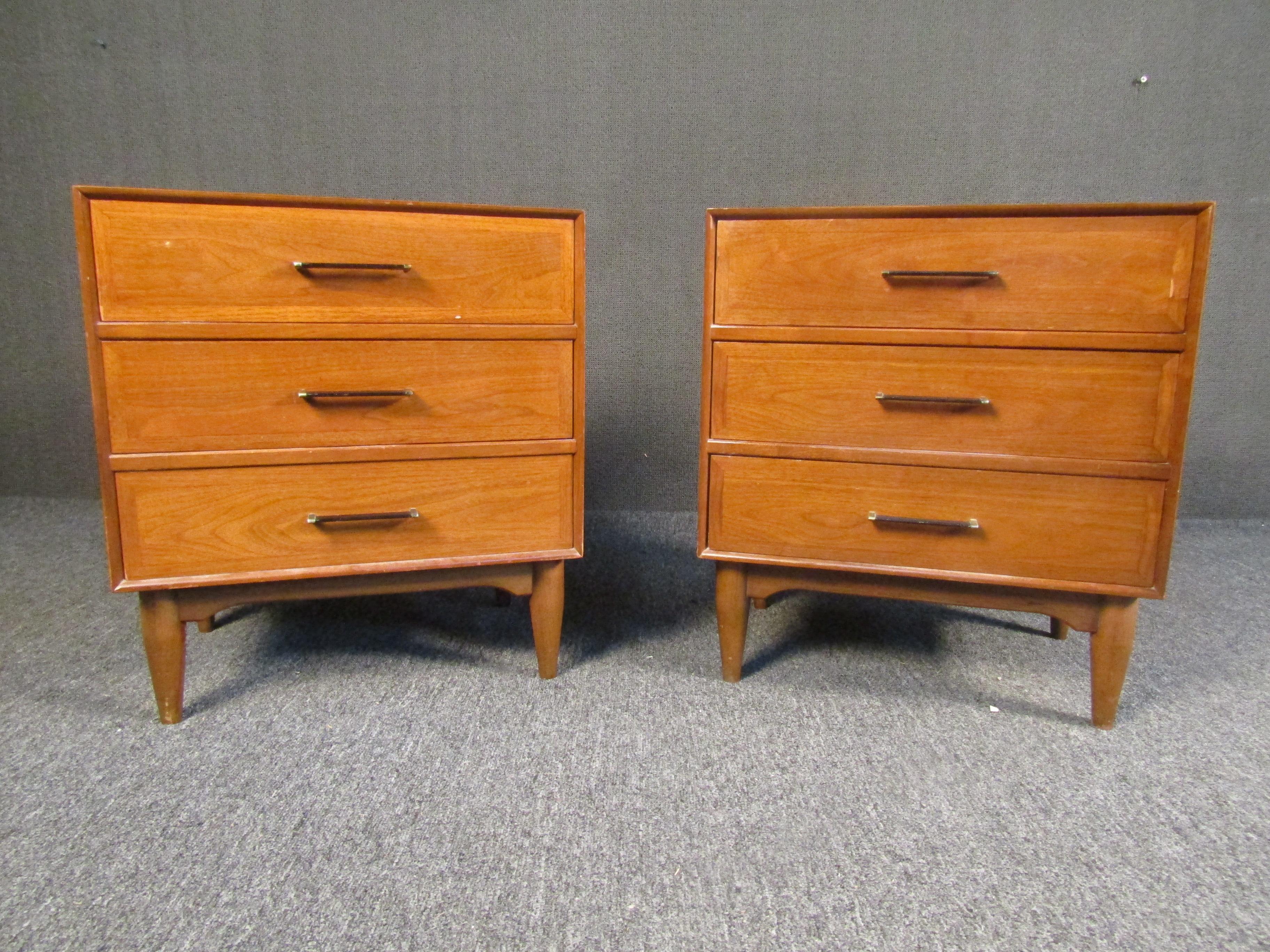Pair of vintage walnut nightstands, perfect for adding timeless Mid-Century Modern style to a bedroom. Rich walnut is complemented by metal handles and sculpted legs. Please confirm item location with seller (NY/NJ).
