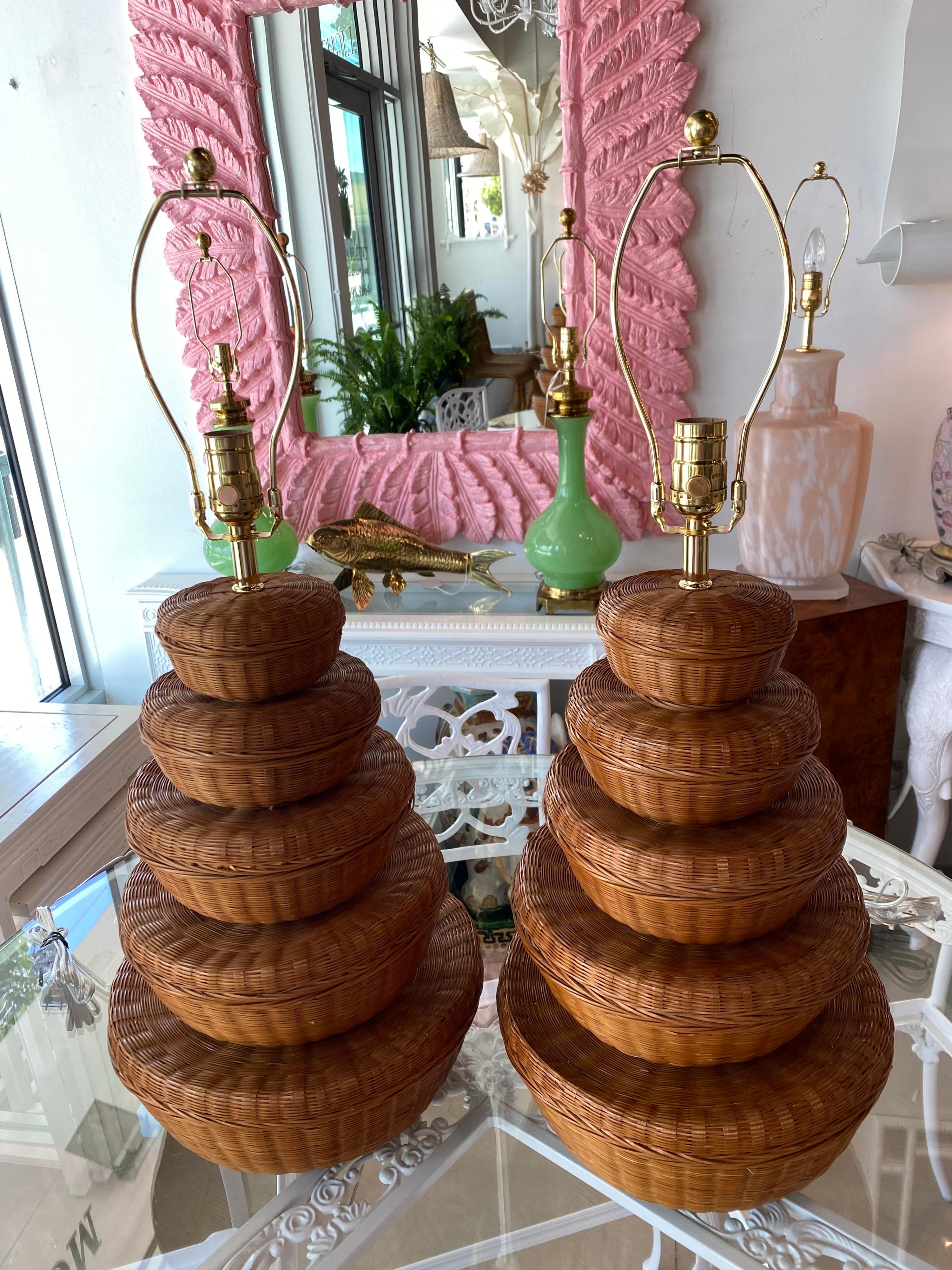 Lovely pair of vintage stacked wicker basket table lamps. No damage to wicker. These have been newly wired with brass 3 way sockets, harp and finial. 
Measures: 21