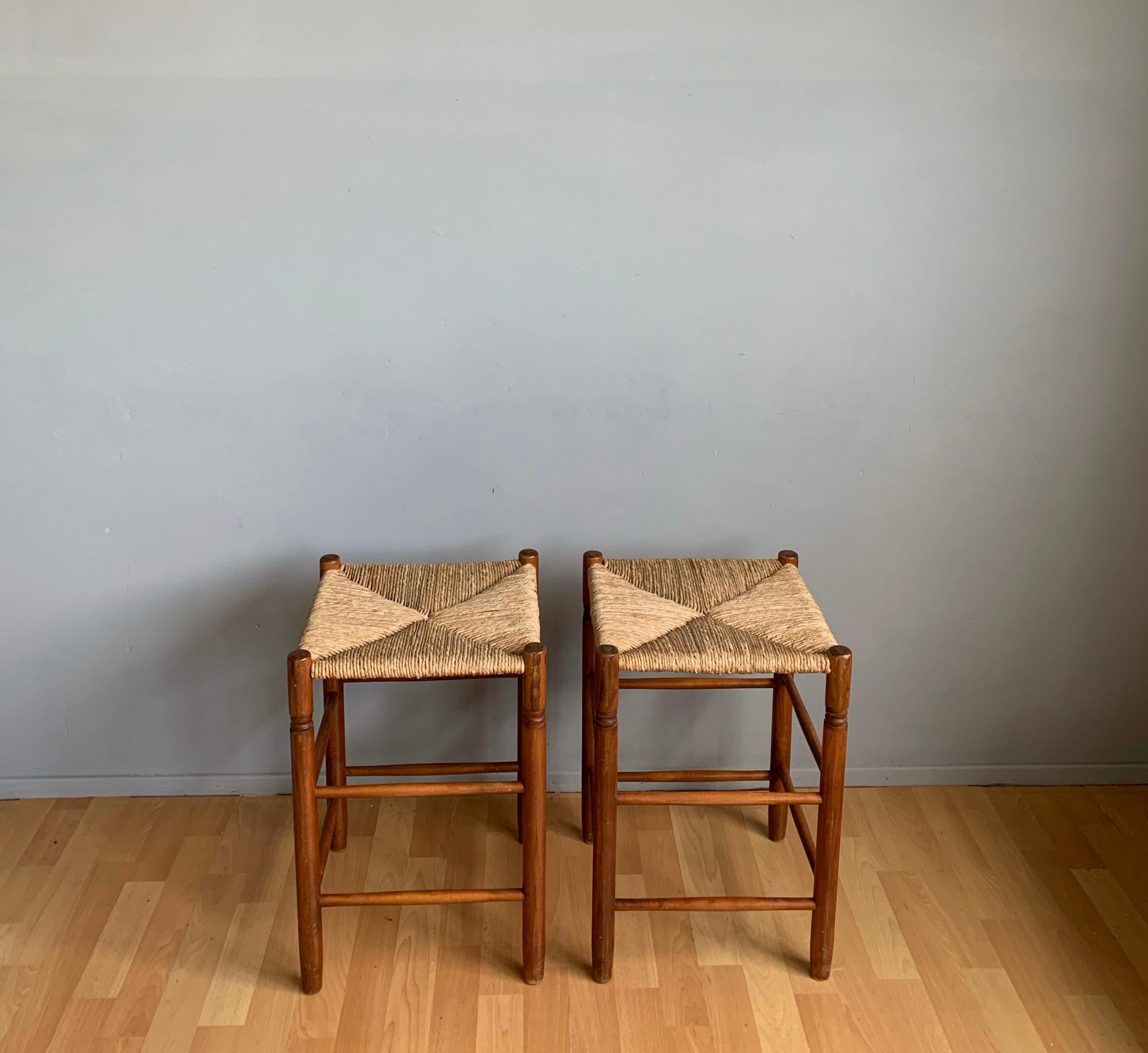 Great pair of handcrafted beechwood with handwoven rush seats stools in the style of Charlotte Perriand.

These sturdy and good looking design stools are an absolute joy to look at and with the original rush seats and the marvelous patina this pair