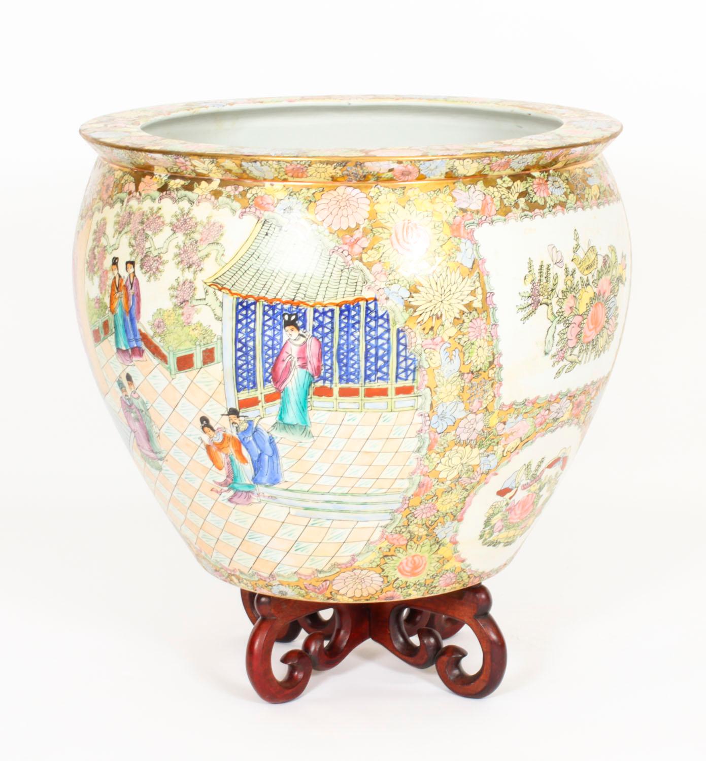 Une belle paire d'énormes vases / bols à poissons en porcelaine peints à la main sur pied  à la manière de la famille rose cantonale de la dynastie chinoise Qing, datant du milieu du 20e siècle.

Les vases comportent des panneaux représentant des