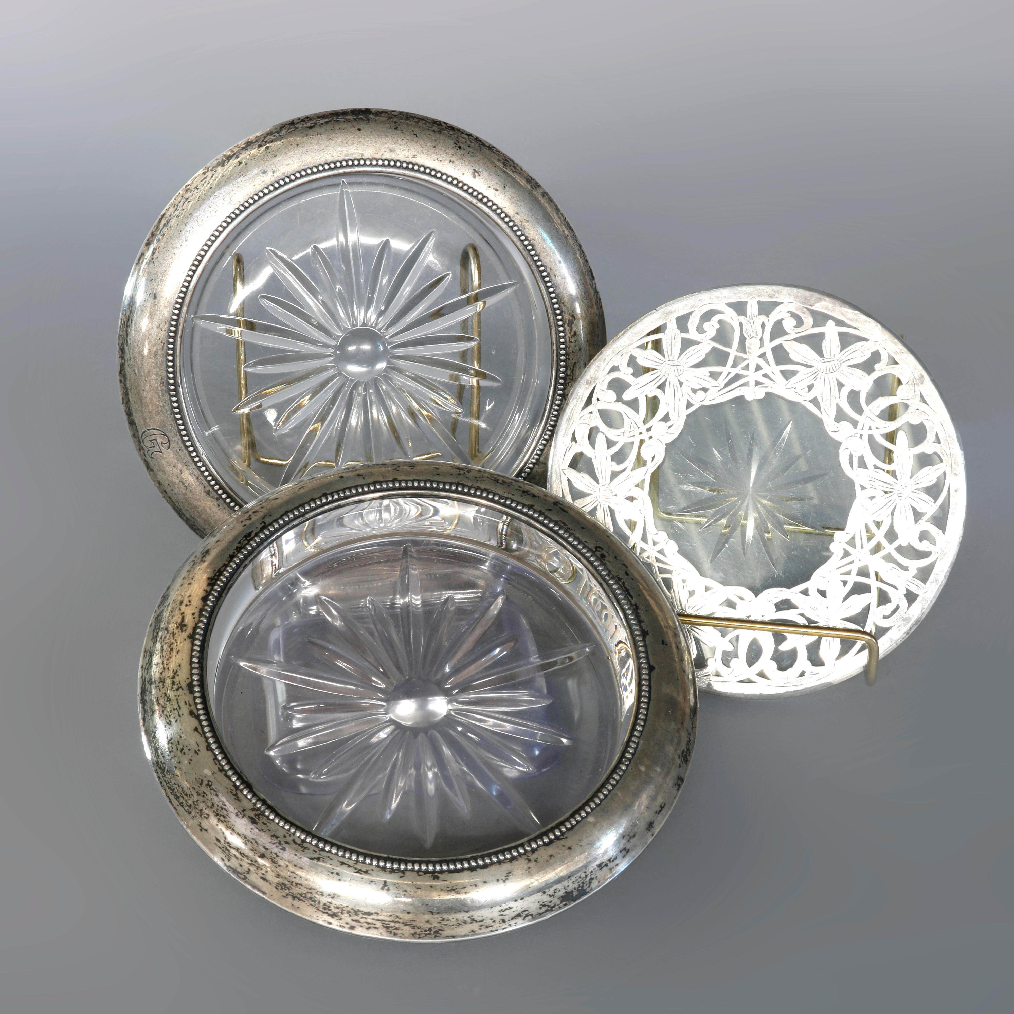 A vintage air of glass coasters offer pressed glass construction with sterling silver rim, set includes pressed glass trivet with foliate filigree overlay, circa 1940.

Measures- Coasters- 6.75
