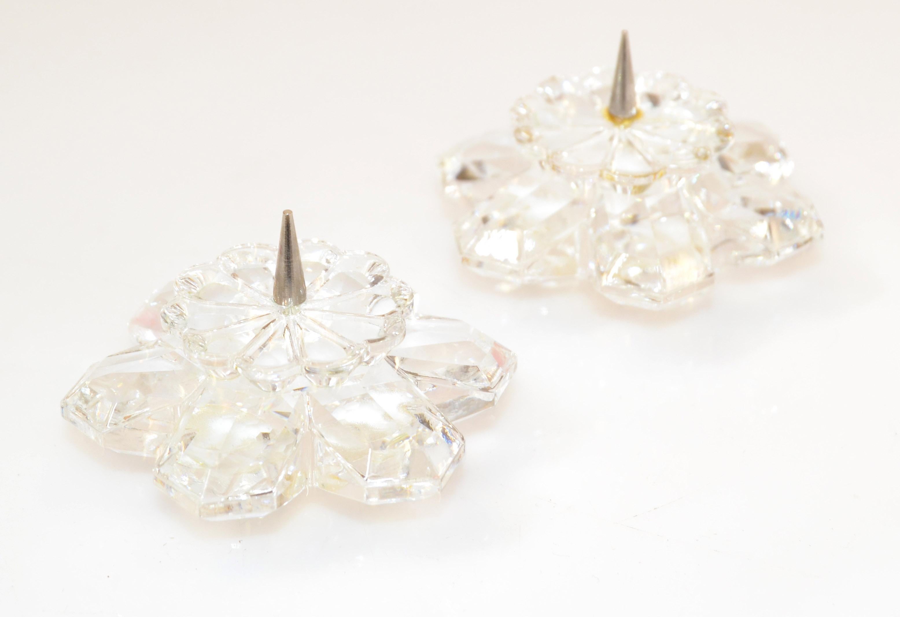 Paire de chandeliers vintage en cristal Swarovski de style Art of Vintage fabriqués en Autriche dans les années 1970.
Base à trois boules de cristal facettées avec soucoupes en forme de fleurs étoilées. 
Signé sur la base, Swarovski.
En bon état