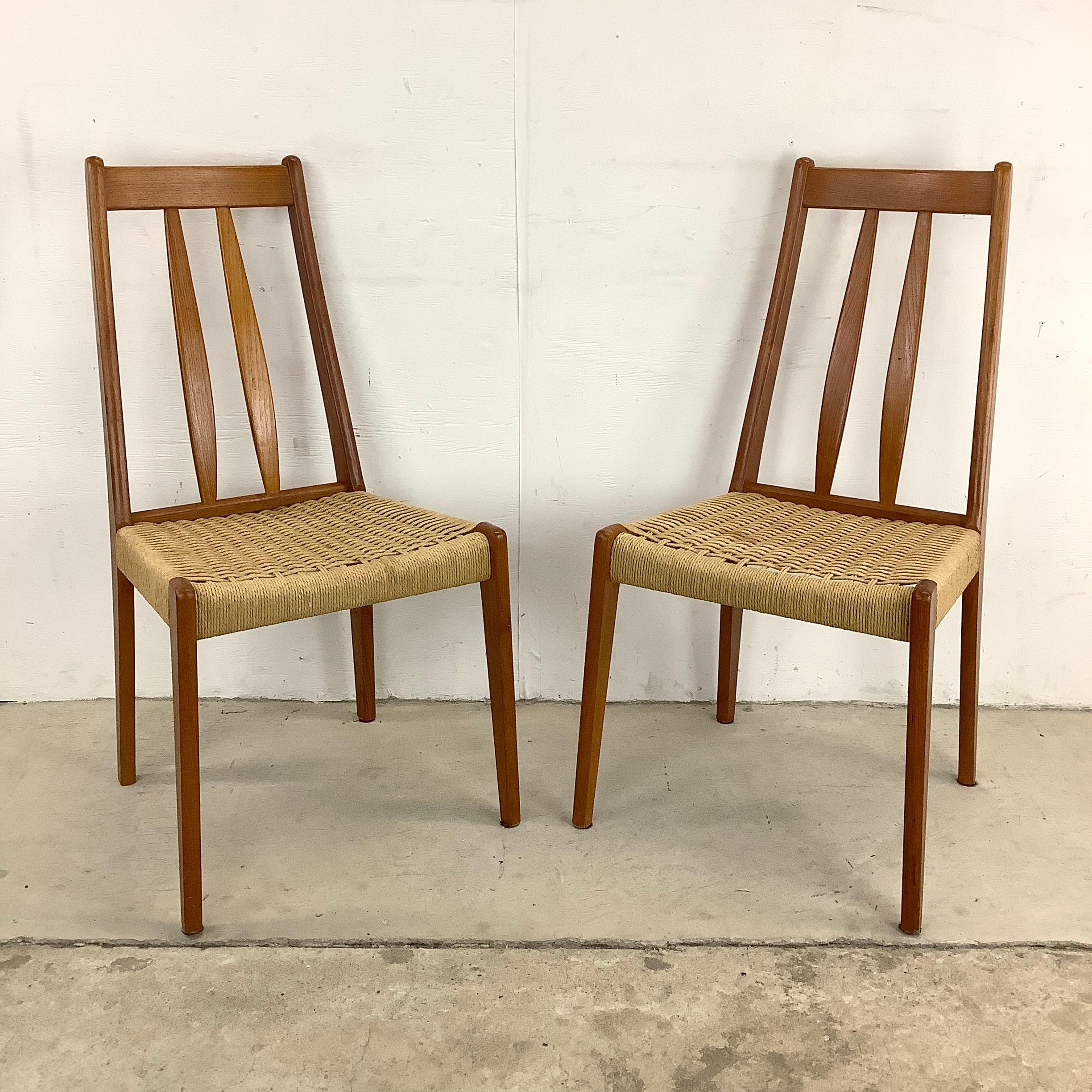 This stylish pair of Scandinavian Modern teak dining chairs feature sculptural teak construction with vintage rope cord seats. The distinctive style of this matching pair of mid-century chairs makes for a striking addition to any interior seating