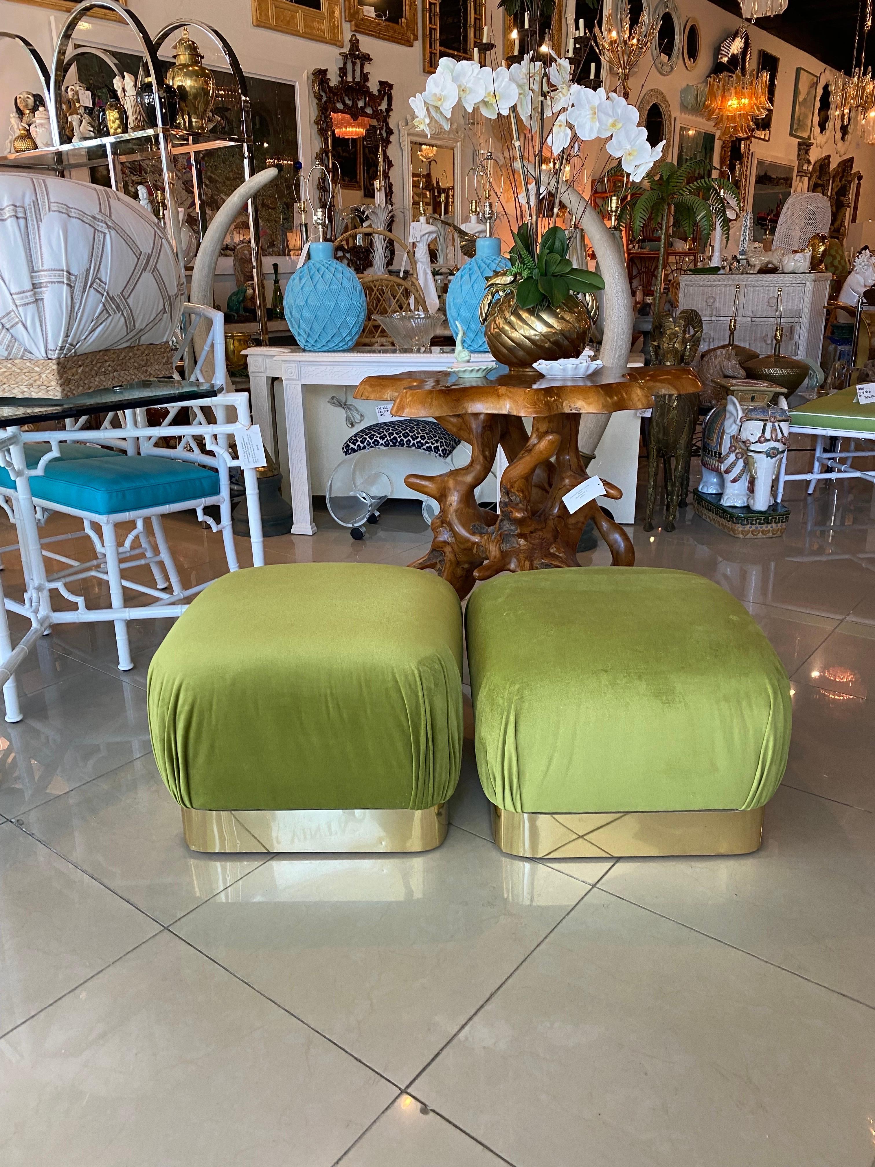 Vintage pair of Karl Springer style poufs, ottomans, benches, stools. Newly upholstered in a moss green velvet. Brass base has been polished but does have minor imperfections such a some dings or impressions. Dimensions: 14.5 H x 21 W x 21 D.