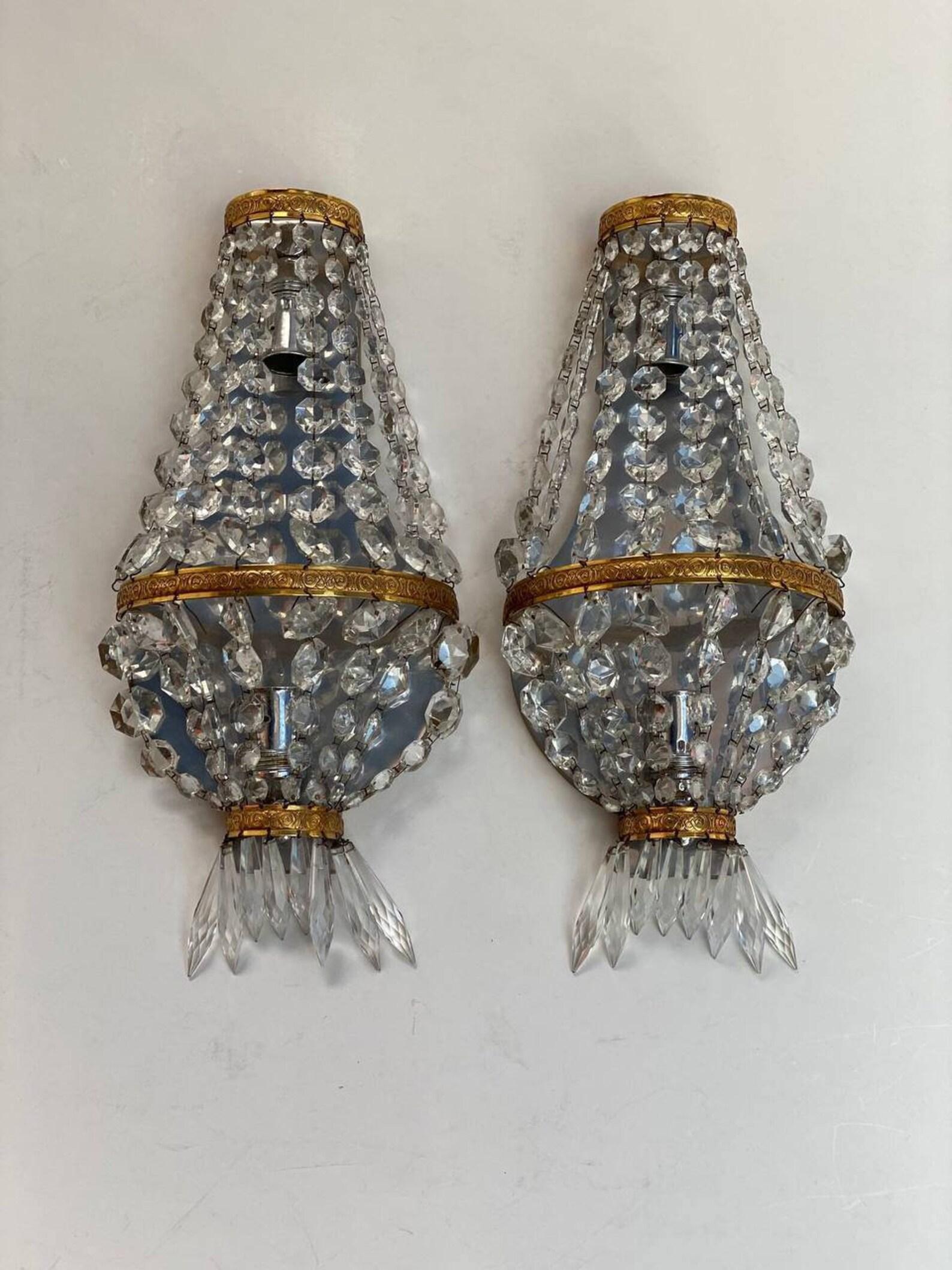 Magnificent vintage crystal lamps in the Empire style, a charming classic from France, 1960s.

 Crystal pendants together with shiny brass details give a chic shine to these sconces. Perfect for all types of classic interiors, in any room.

 Without