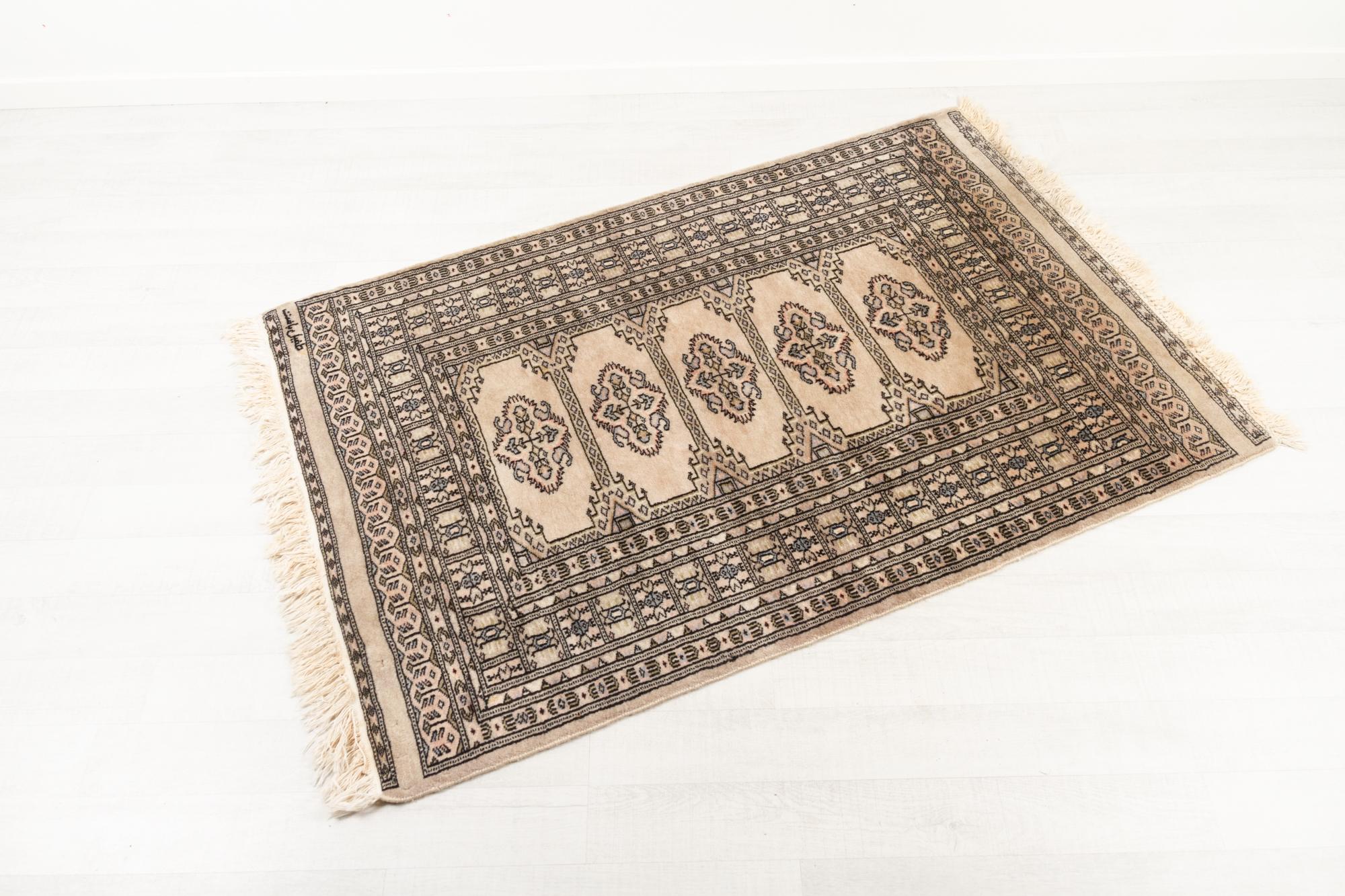 Vieux tapis Pakastani.
tapis 100% laine noué à la main de Lahore, au Pakistan, datant des années 1970. Signature dans le coin. 
Mesure 141 x 94 cm (155 cm avec les franges).
Seule une petite usure, de légères différences de nuances.