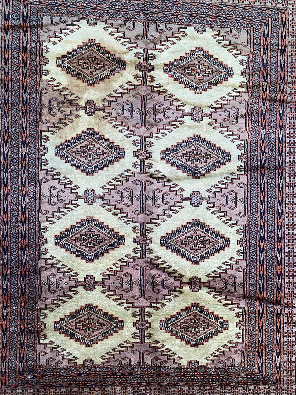 Schöner pakistanischer Teppich aus der Mitte des Jahrhunderts mit geometrischem turkmenischem Muster und schönen Farben in Rosa, Lila, Gelb und Schwarz, vollständig und fein handgeknüpft mit Wollsamt auf Baumwollgrund.