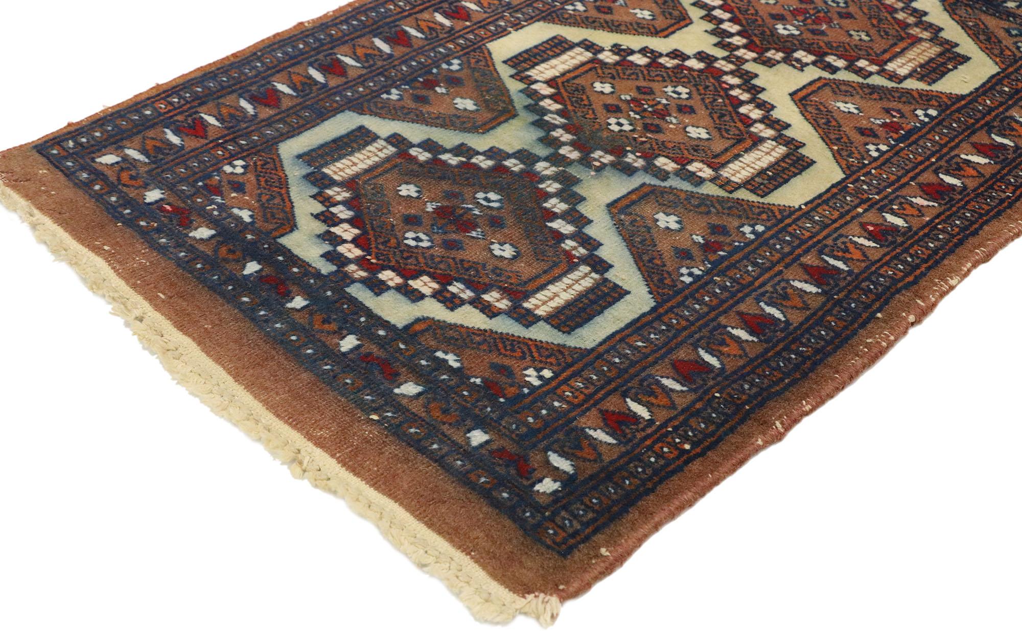 74914 Petit tapis pakistanais vintage, 01'07 x 02'02. Embarquez pour une odyssée sauvage où le charme nomade se mêle sans effort à l'enchantement tribal dans ce tapis pakistanais vintage en laine noué à la main. Au cœur de son design, trois