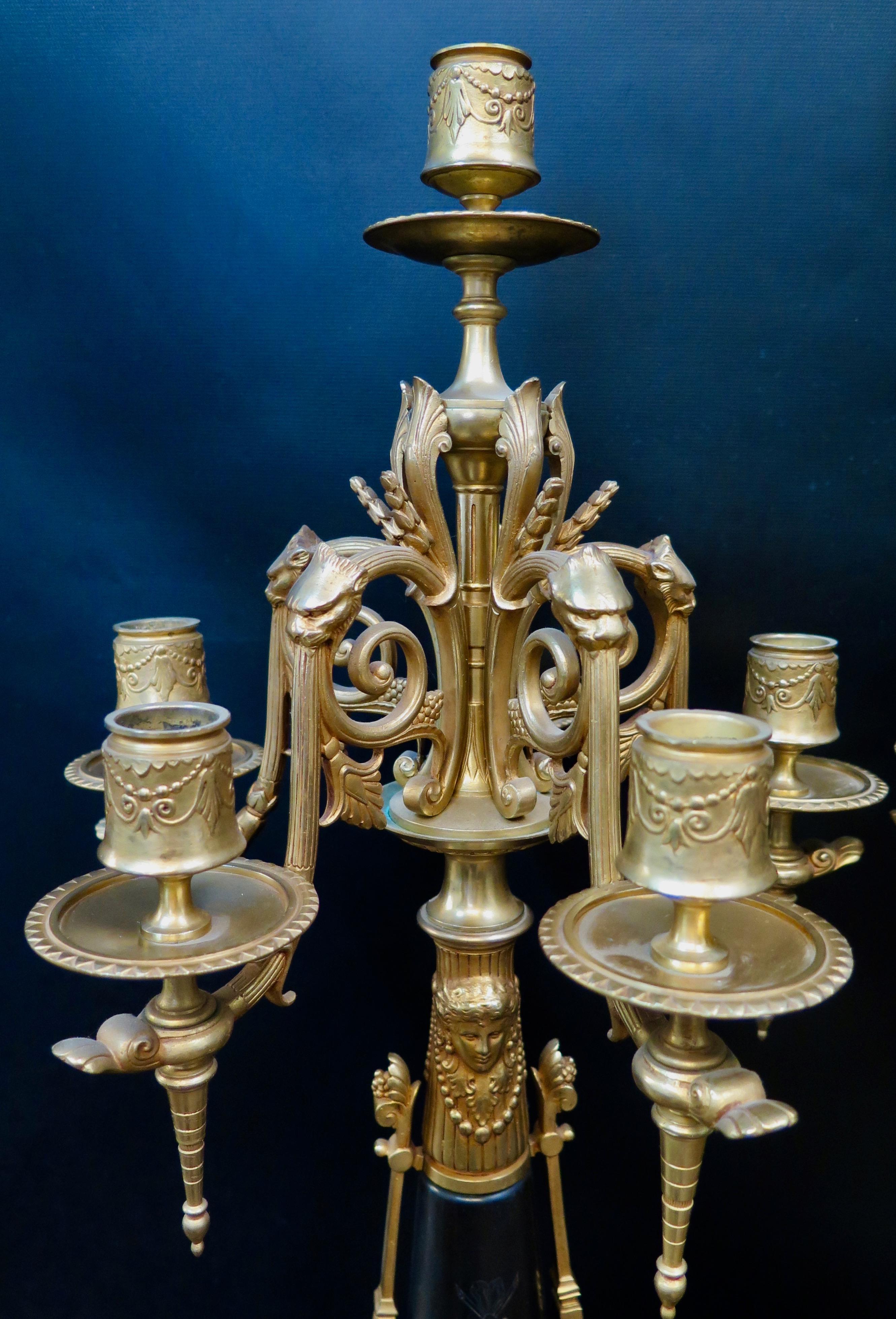 This pair of dramatic and decorative French more bronze and marble candelabra date from the late 19th century and, clearly, were influenced by the artisans of the Victorian period. These five arm candelabra feature an elegant neoclassical design,