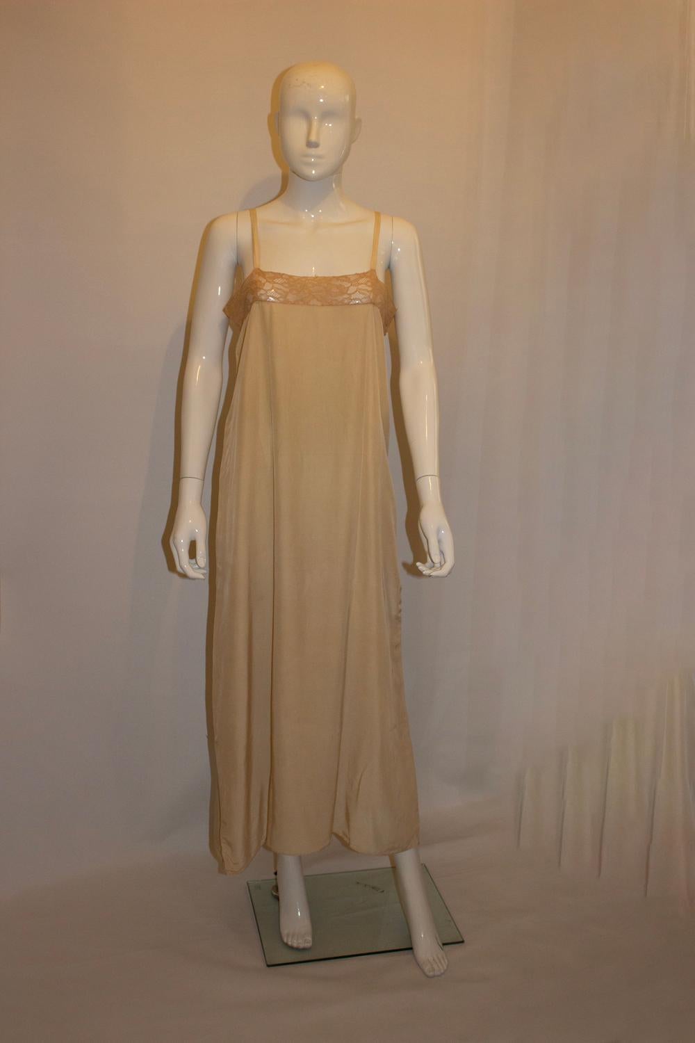 A stunning vintage silk slip with wonderful lace detail. The silk slip is in a pretty coffee colour, and has lovely lace detail across the top. 
Measurements: Bust up to 37'', length 53''