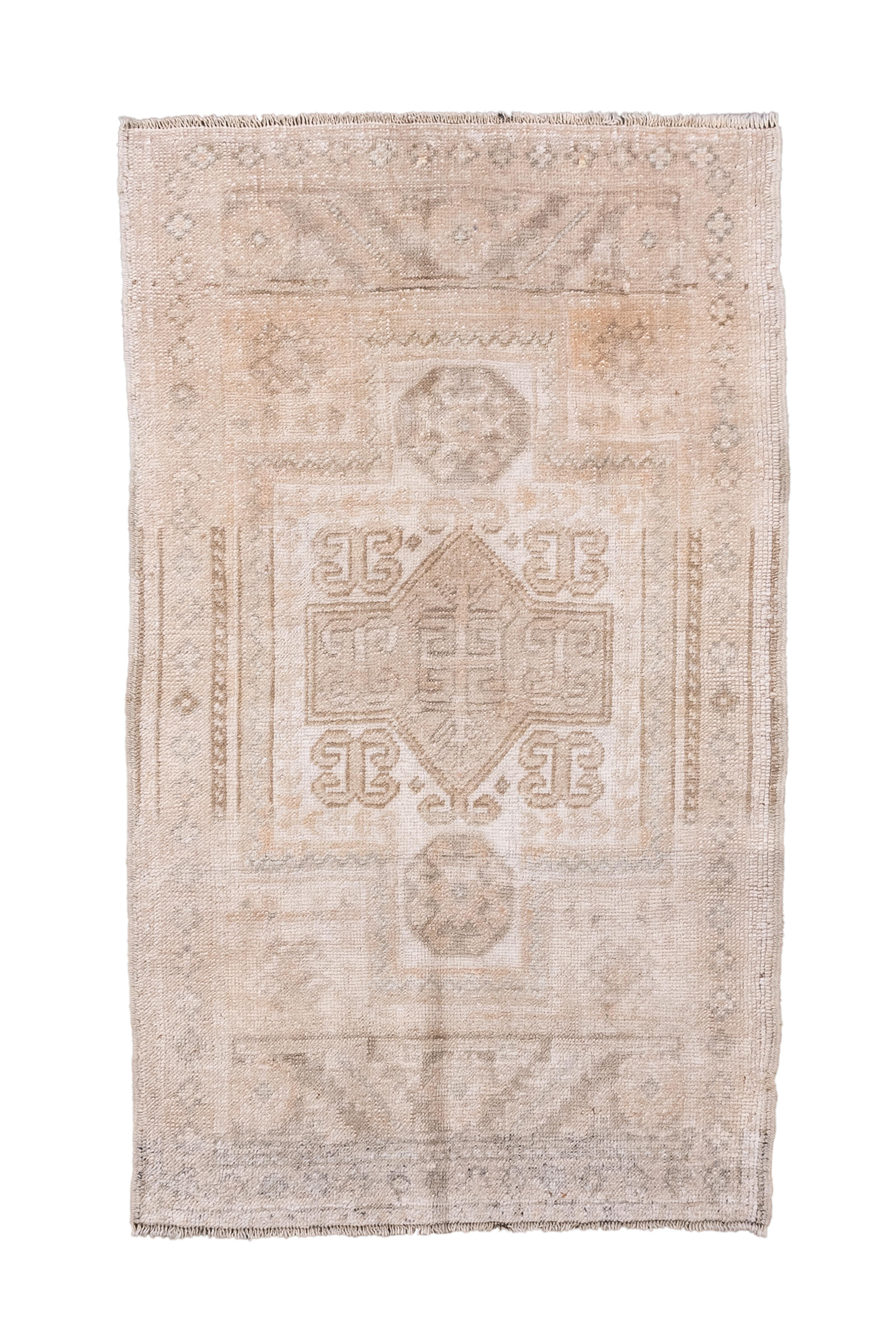 Un tappeto vintage Oushak della Turchia occidentale, delicato e splendidamente sbiadito, caratterizzato da un disegno geometrico minimalista a medaglione nei toni dell'avorio, del sabbia e del beige tenue. L'aspetto leggero e sbiadito del tappeto e