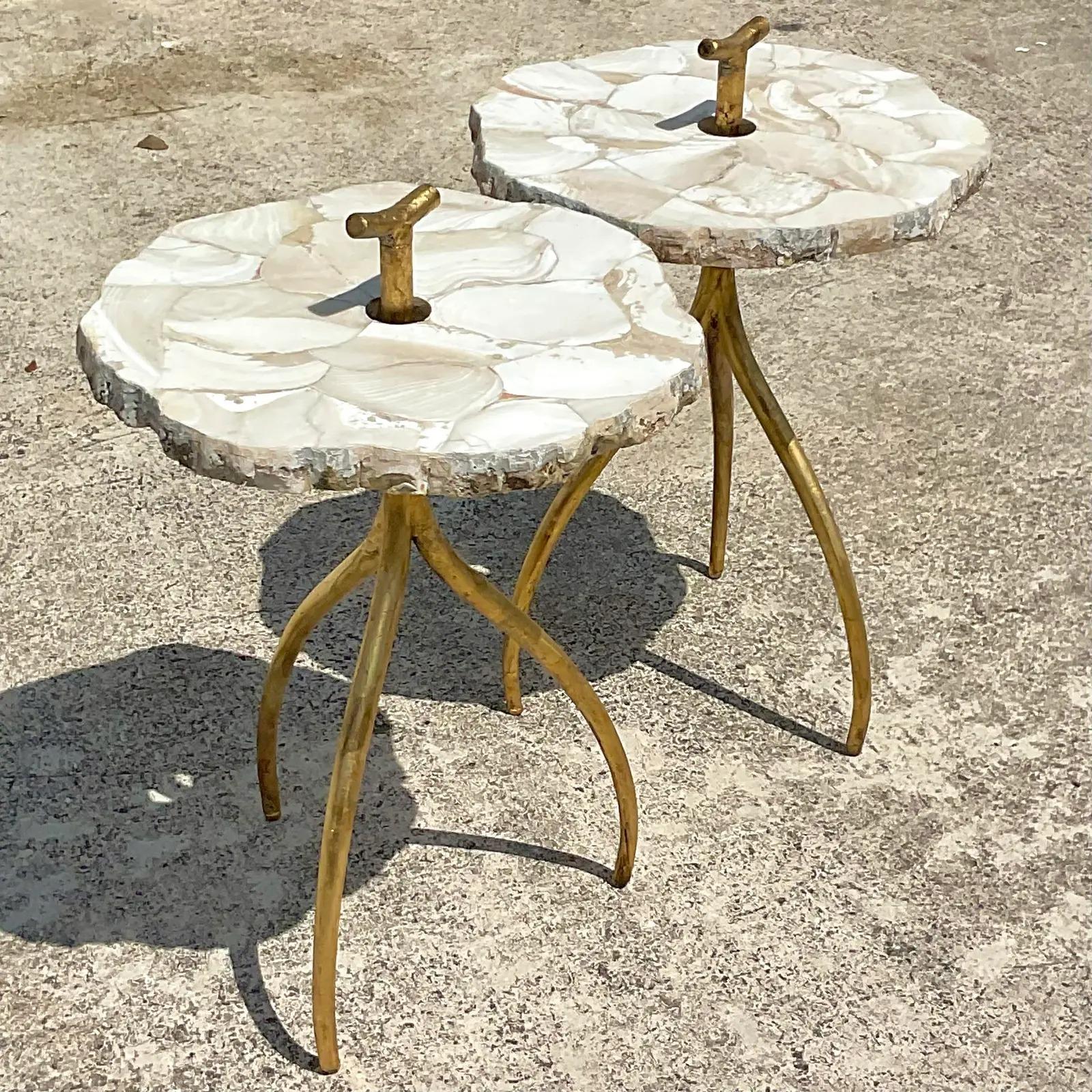 A fantastic pair of vintage Contemporary drinks tables. Made by the iconic Palecek group. A sticking slab of natural clamshells embedded in marble on a gently curving gilt pedestal. A handle protruding from above the top for easy movement. Great for