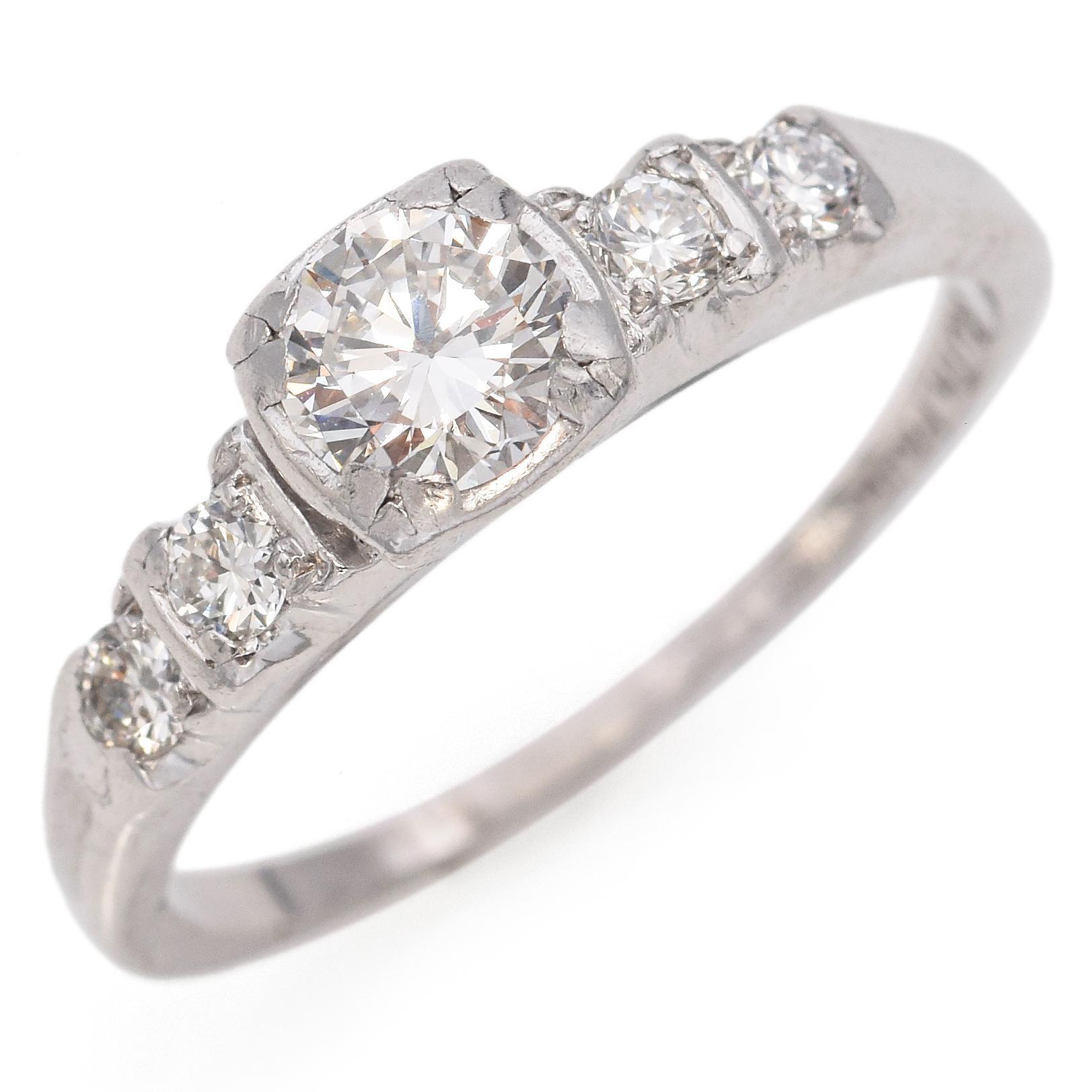 Elegant and Timeless, this stunning 5-stone engagement ring features a larger, dazzling center stone, beautifully surrounded by four smaller Round Brilliant-Cut Diamonds. Each diamond is expertly set to enhance its brilliance and sparkle. Crafted in