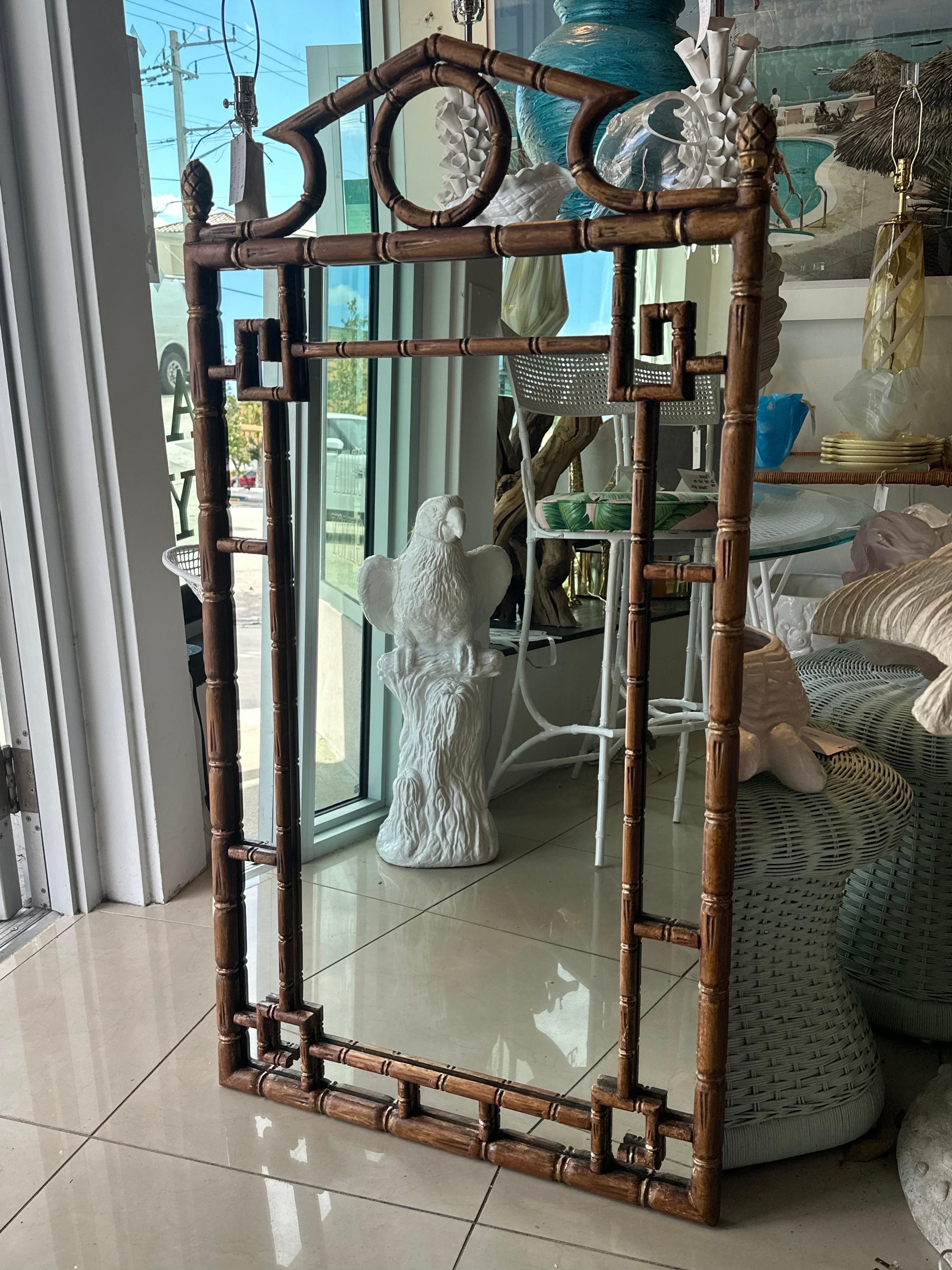Vintage faux bamboo rattan greek key pagoda top wall mirror. Original brown painted finish. Original mirror has a patina spot (pictured). If you would like this lacquered in another color please email for price. Dimensions: 49 H x 26 W x 1.5 D. 