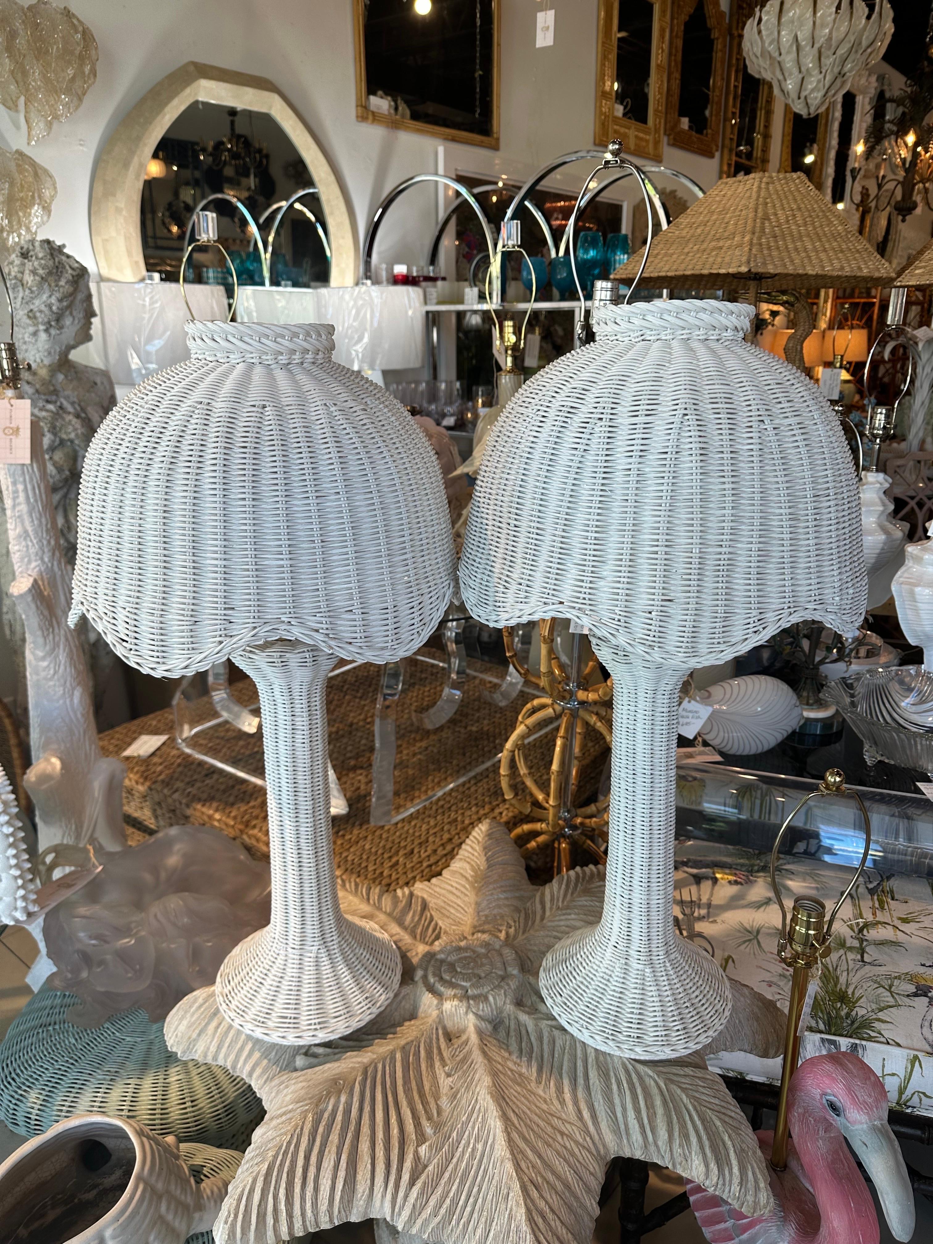 Vintage 1970s pair of white wicker table lamps with original scalloped matching lampshades. These have been newly wired with 3 way brass sockets & turn, clear cords. Original white wicker color with no seen damage or defects. Please inquire if you