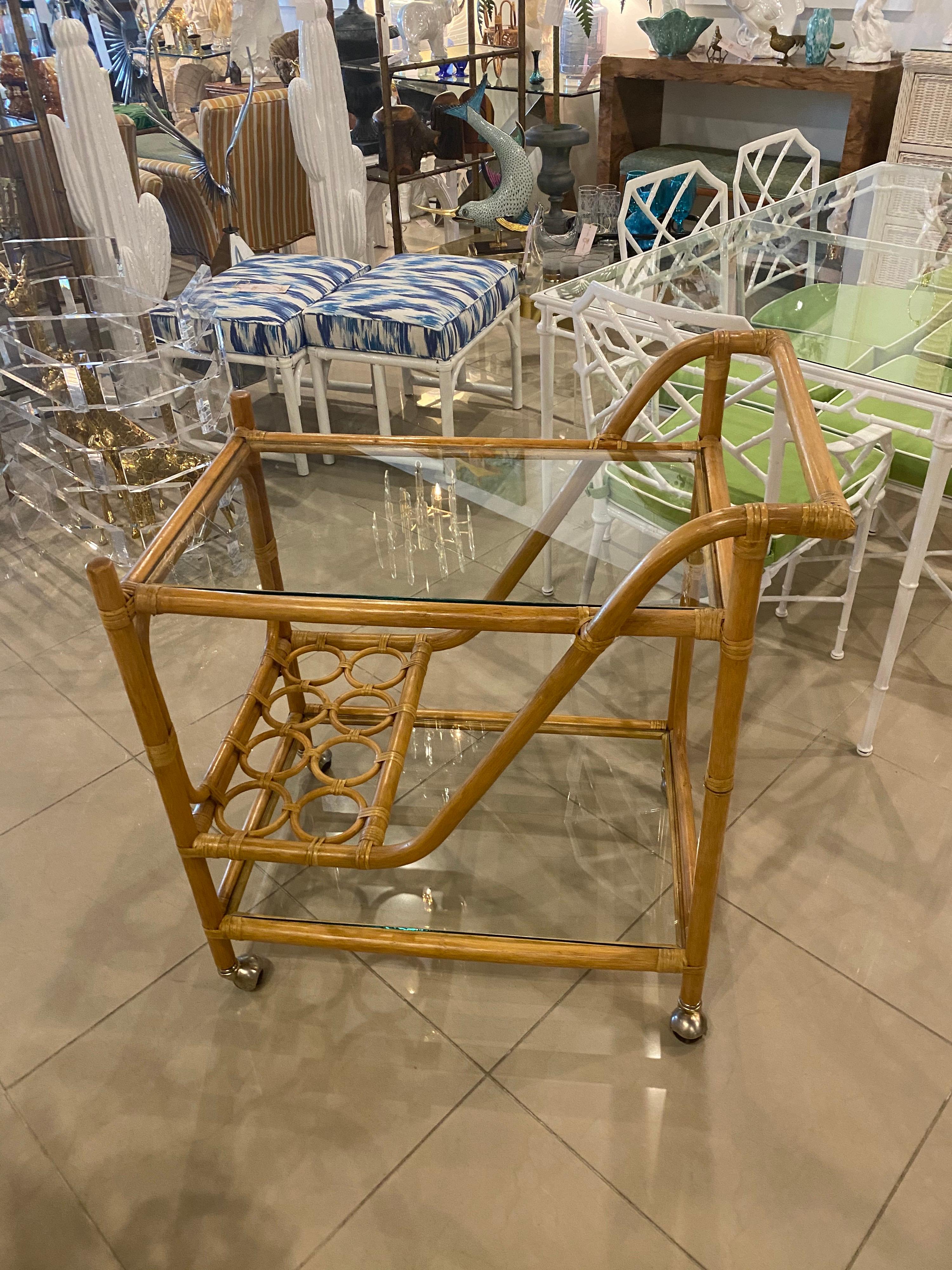 Lovely vintage rattan bar cart with chrome castor wheels and double glass shelves. I love that there's a place to hold wine bottles! New glass shelves.