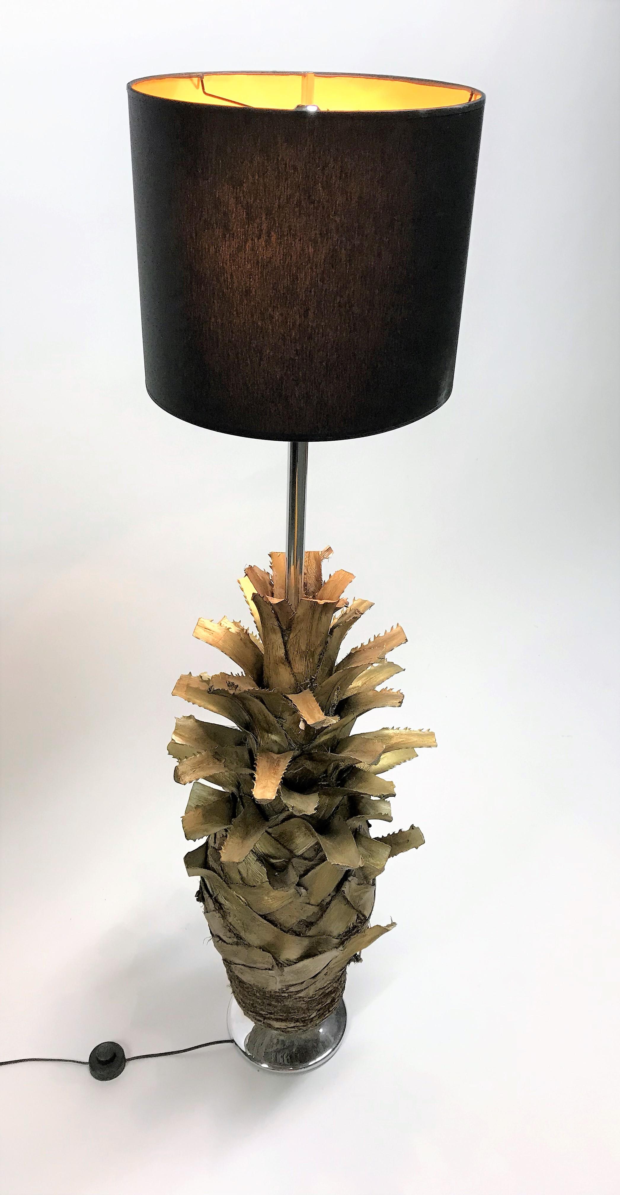 Unique vintage golden palm tree floor lamp.

Unlike many other palm tree floor lamps, this one isn't made out of brass or gilt metal but consists of a genuine gilded palm tree trunk with a chrome rod providing two bakelite lightpoints. It sits on