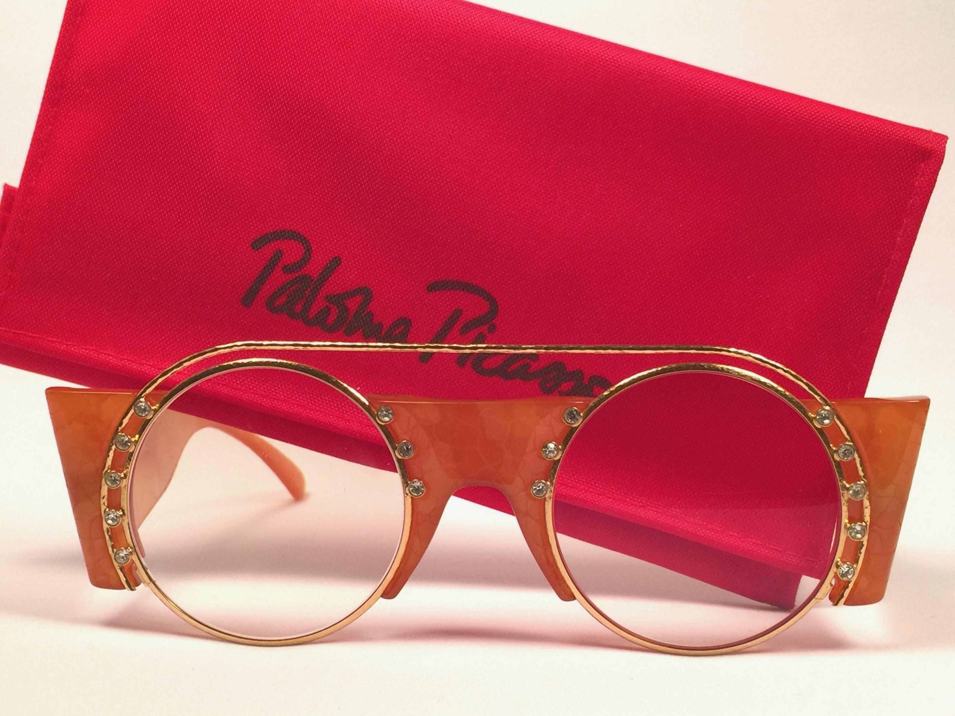 Mint Vintage Paloma Picasso Gold & Honig Frame mit Strass Details Sonnenbrille.

Hergestellt in Deutschland in den 1980er Jahren. 

Rahmen mit leichten lagerungsbedingten Gebrauchsspuren und Anlaufen. 

Hergestellt in Deutschland.
