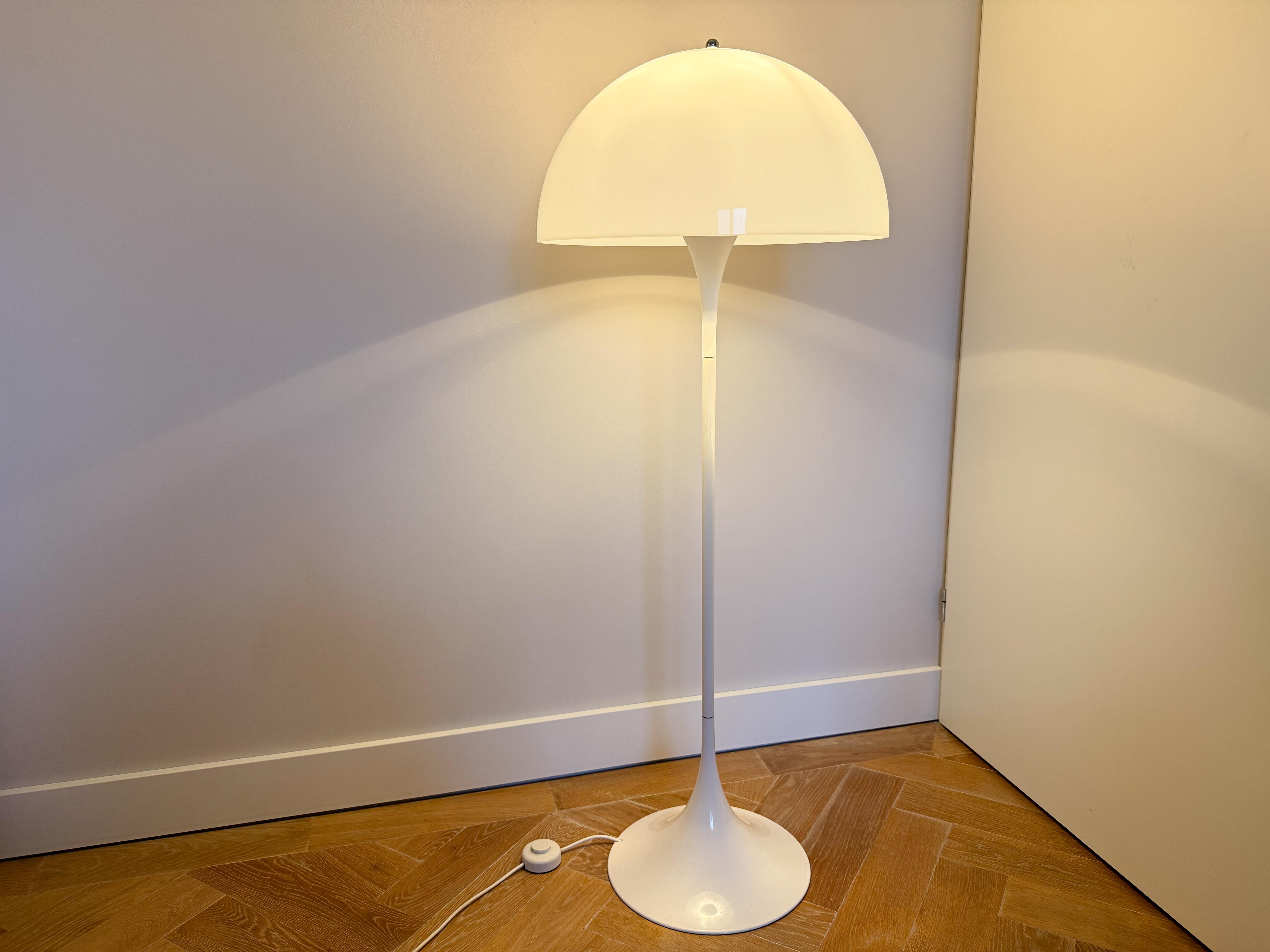 This iconic Panthella floor lamp, designed by Verner Panton for Louis Poulsen in the 1970s, is a perfect blend of form and function. Its sculptural, minimalist design features a smooth, hemispherical acrylic shade that gently diffuses light, paired