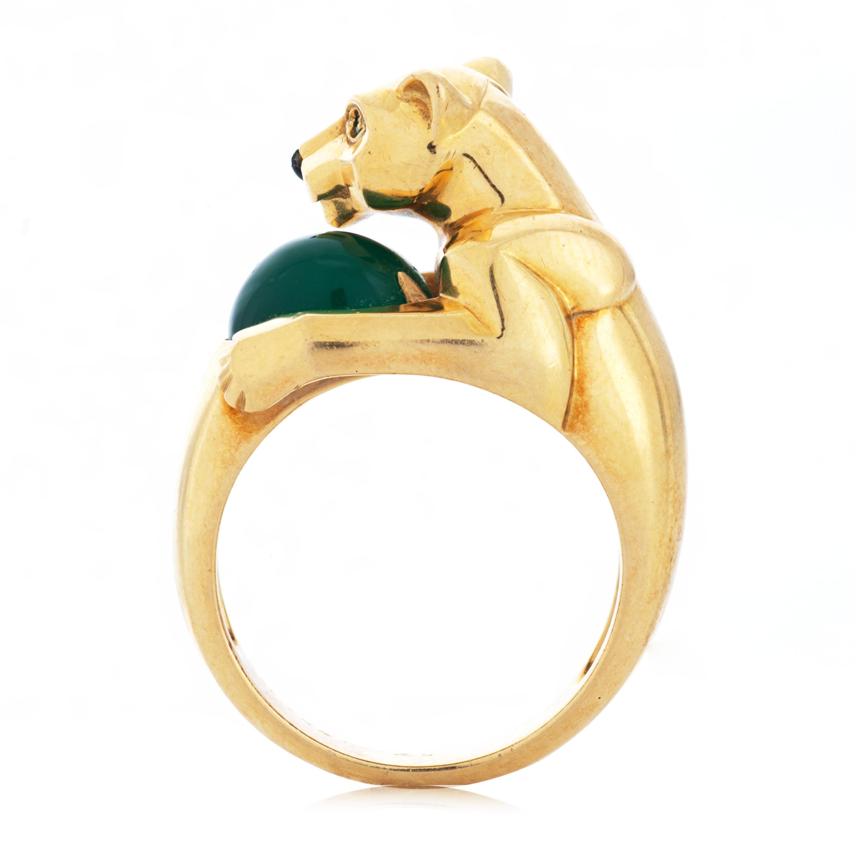 This vintage Panthere De Cartier ring features a panther holding an oval cabochon green chrysoprase.  The panther itself has two round emerald eyes and a carved onyx nose, set in 18k yellow gold.  Accompanied by Cartier box.

The ring measures