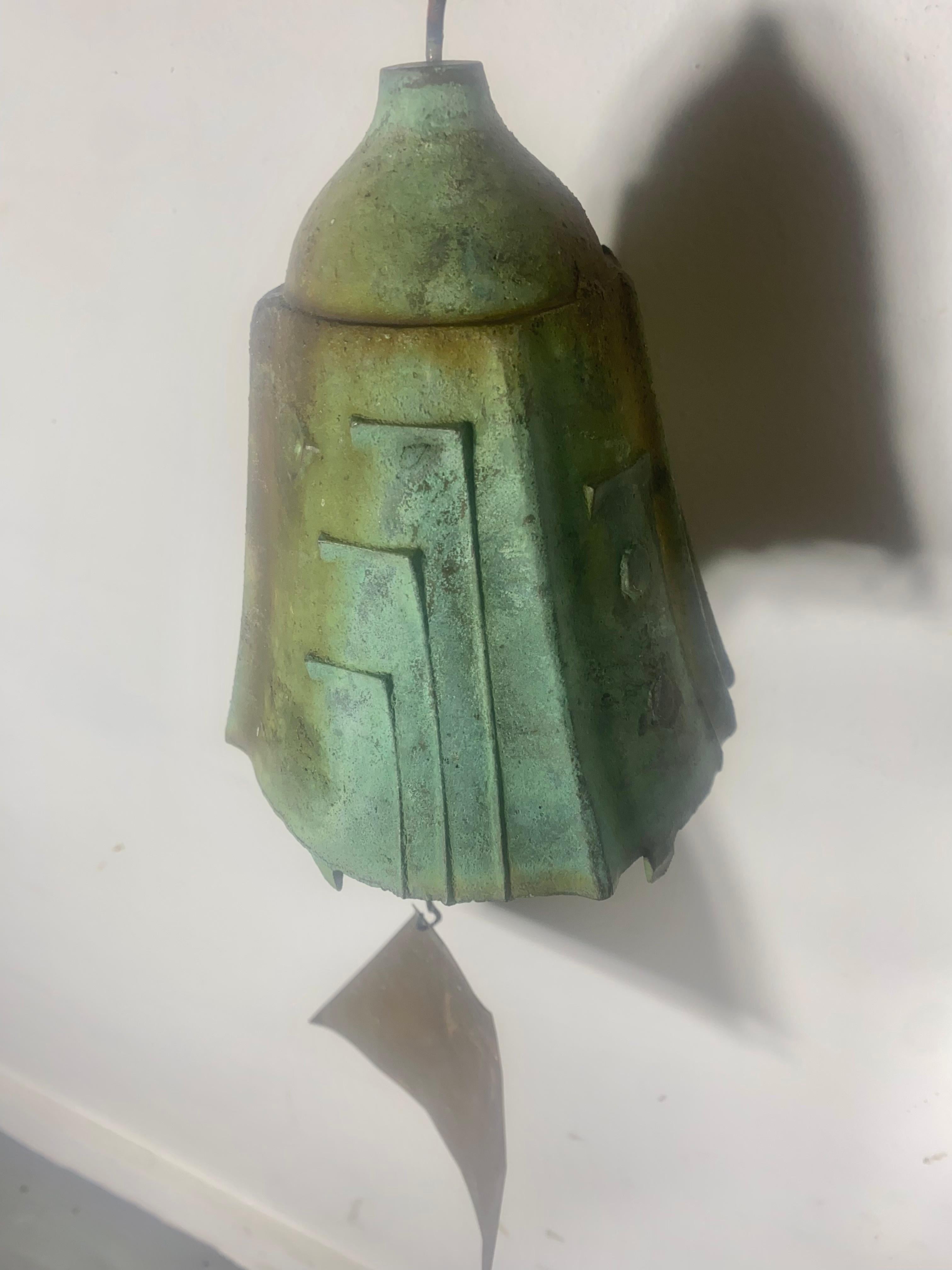 Wind chime/bell designed by architect, Paolo Soleri for Arconsanti (the city he designed and built in Arizona in 1970). Bronze cast elements with verdigris patina and multi-color pigmented fin. Early production with attractive colors employed.