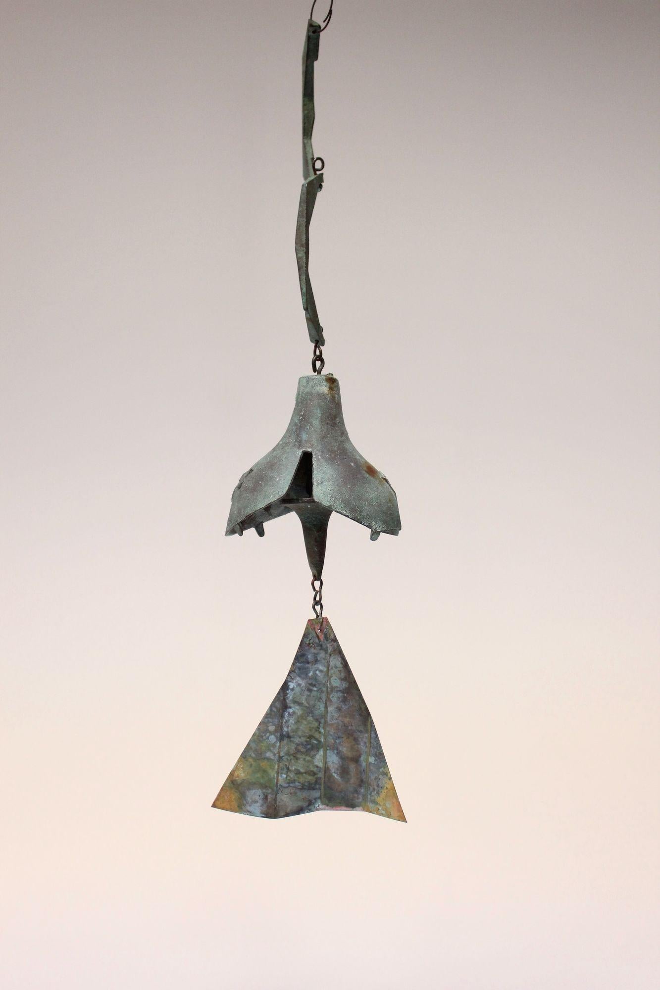 Wind chime/bell designed by architect, Paolo Soleri for Arconsanti (the city he designed and built in Arizona in 1970).
Bronze cast elements with verdigris patina and multi-color pigmented fin. Early production with attractive colors