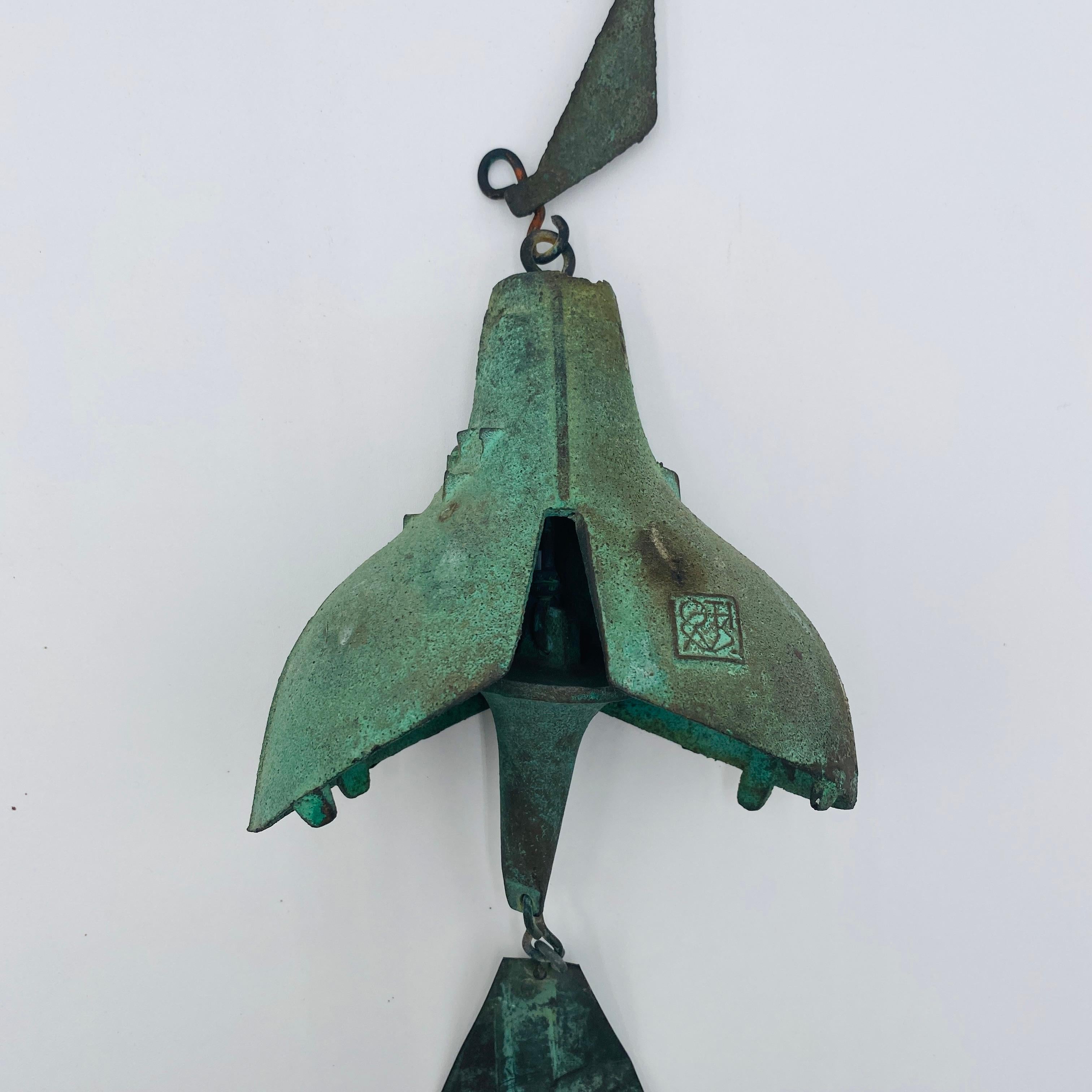Vintage Paolo Soleri bronze windbell, c. 1970. It has a lovely patina that only time can create. This wind bell has a rare form with stunning geometric designs and retains the original kite. The Arcosanti cipher is visible on the front of the bell.