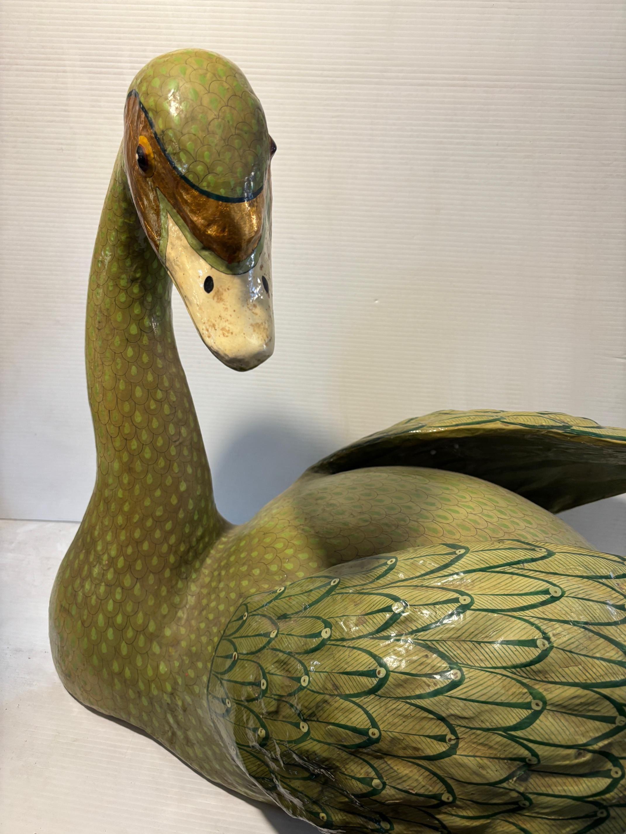 Questo affascinante cigno d'epoca, realizzato in cartapesta all'inizio del XX secolo, presenta una verniciatura verde davvero unica. Con una lunghezza di 30 pollici, questo pezzo emana un'eleganza antica grazie ai suoi dettagli intricati e al suo