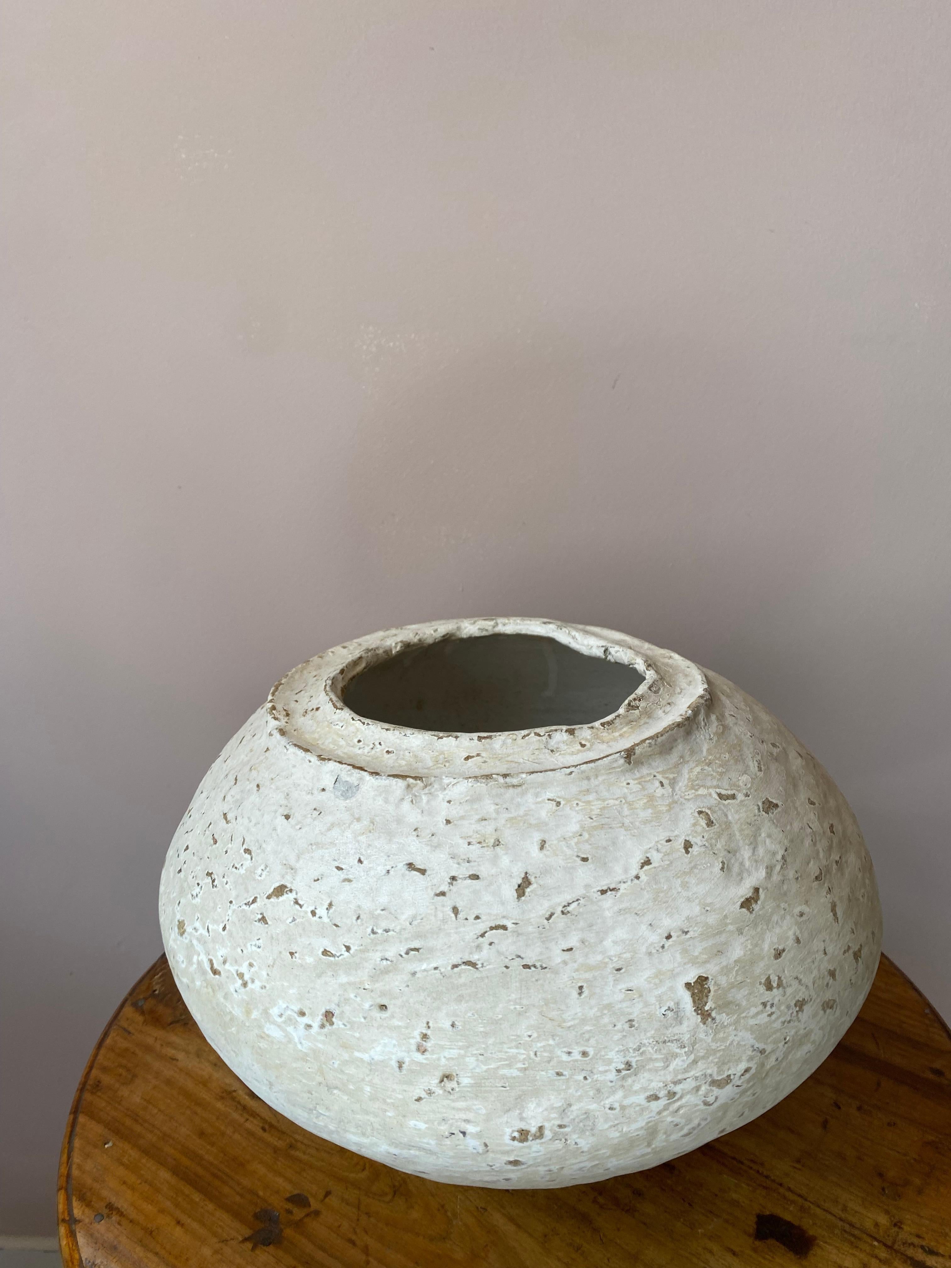 This vintage paper mached vase has been sourced in Rajasthan where paper mached was first used for its quality of isolation. 
Its white colour makes it a very décorative item.