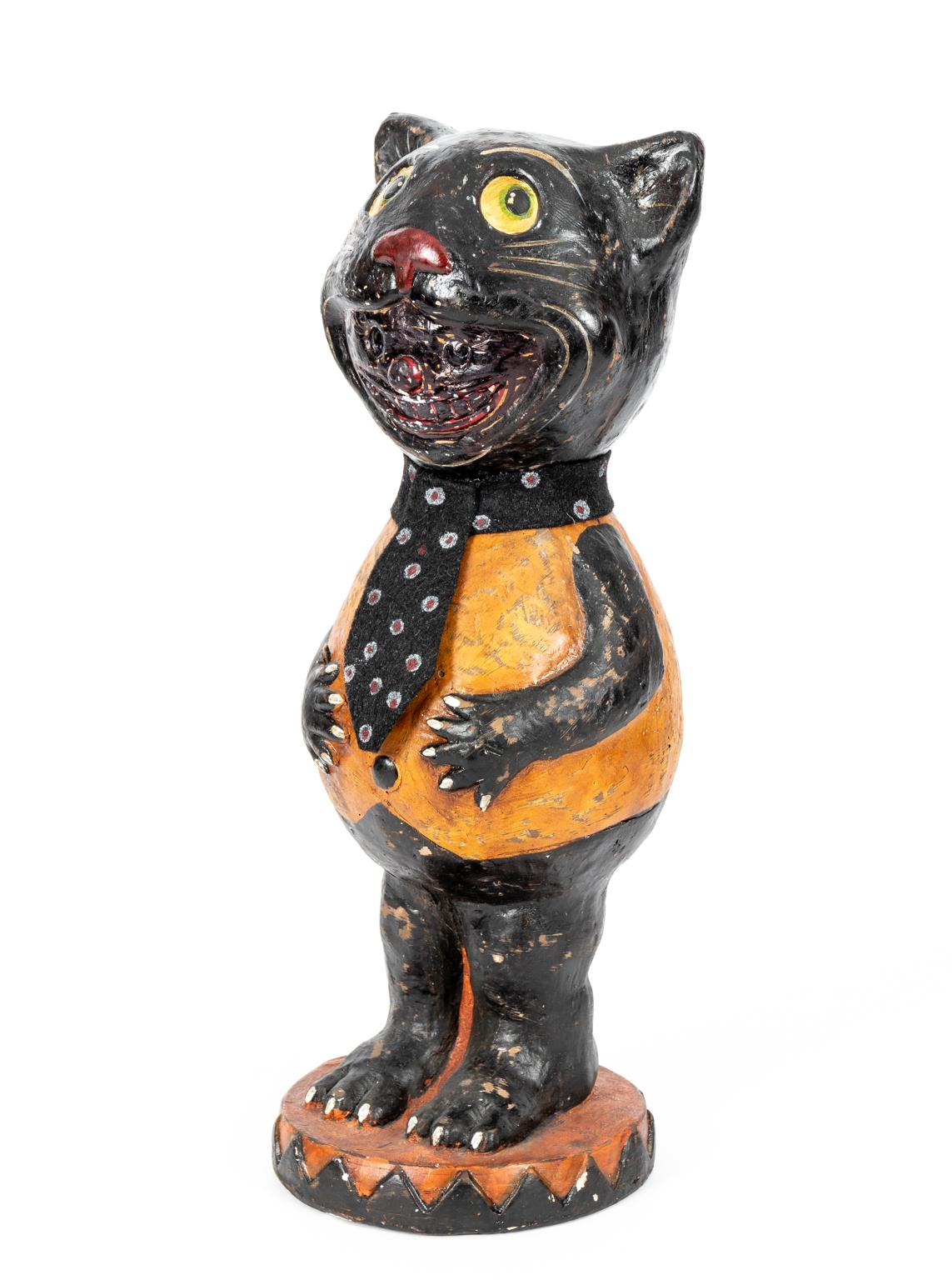 Vintage Halloween themed Papier Mache cat with fabric tie and clown face in its smile. Origin and period of manufacture unknown. Please note of wear consistent with age.