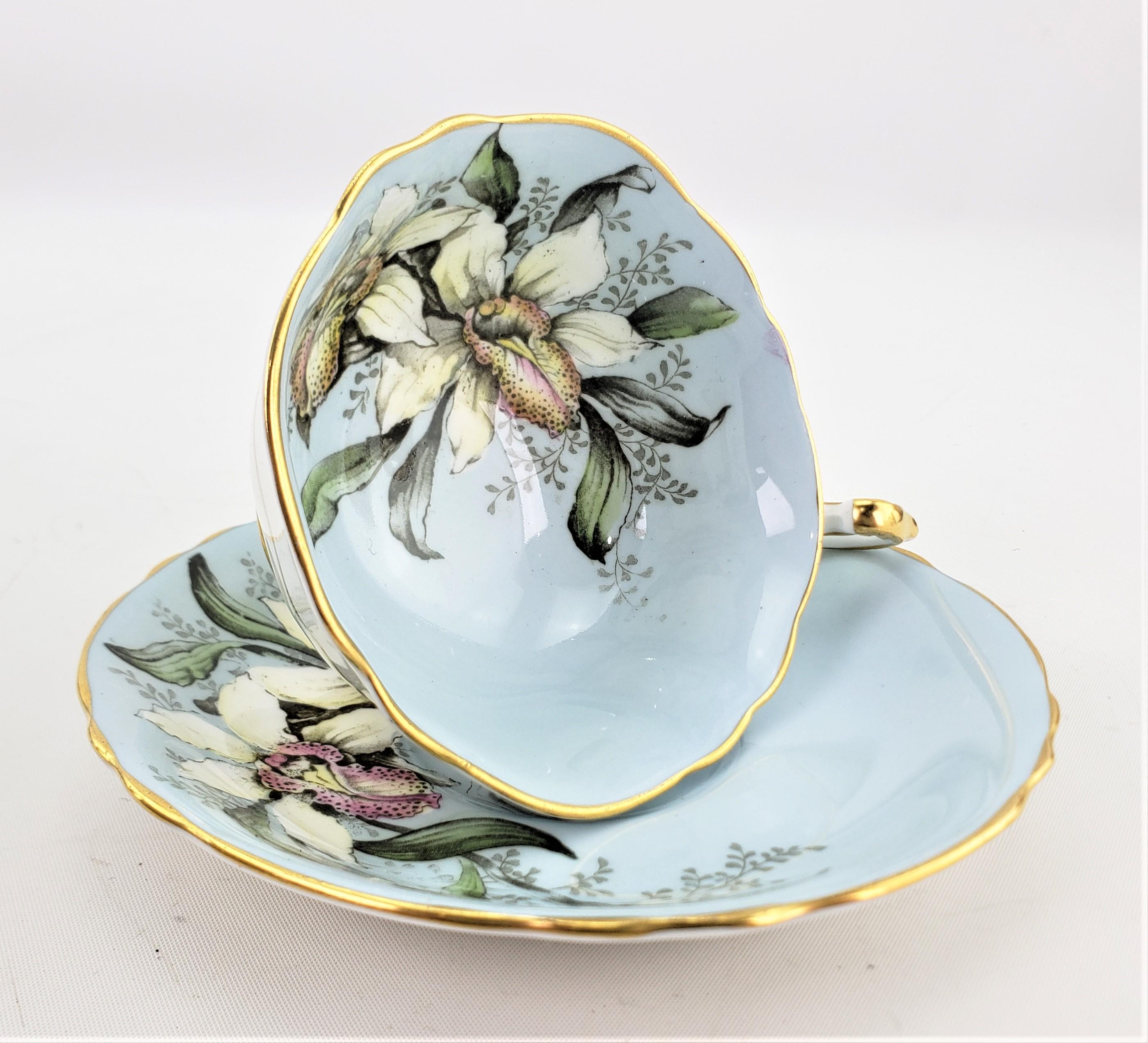 Dieses Set aus Teetasse und Untertasse wurde um 1960 von der renommierten englischen Porzellanfabrik Paragon hergestellt. Das Set hat einen rotkehlchenblauen Grund mit einem großen Blumenmuster auf der Innenseite der Tasse, das sich auch auf der