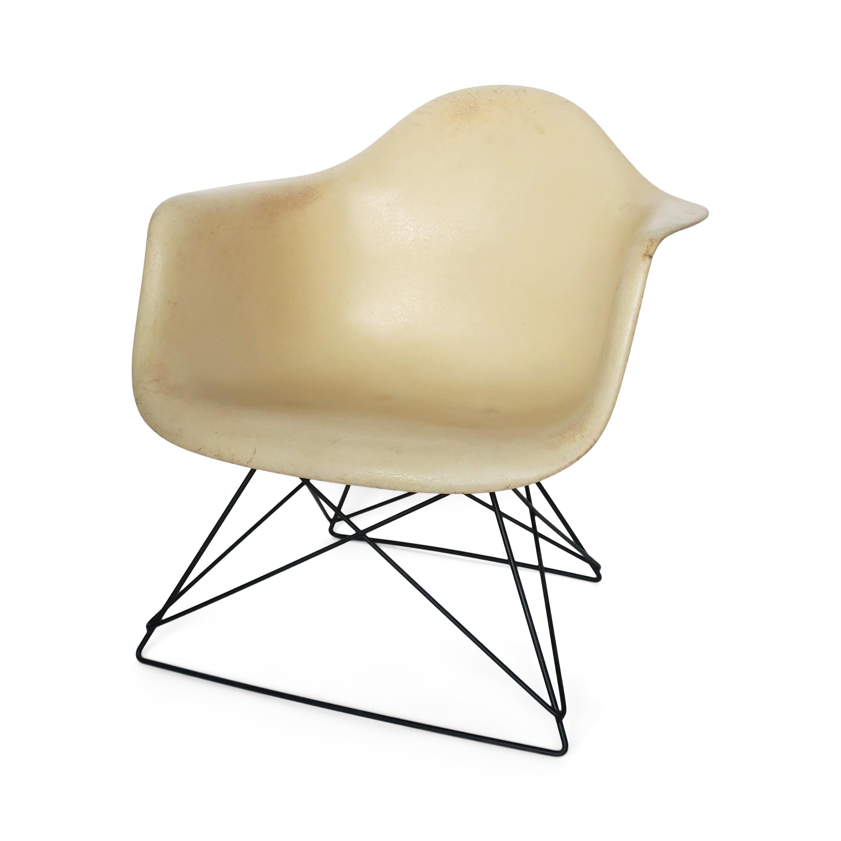 An early example of Charles and Ray Eames' iconic chair design for Herman Miller. Beautiful parchment color with exposed fibers, on a replacement black metal cat's cradle base. 

In vintage condition with wear consistent with age and use,