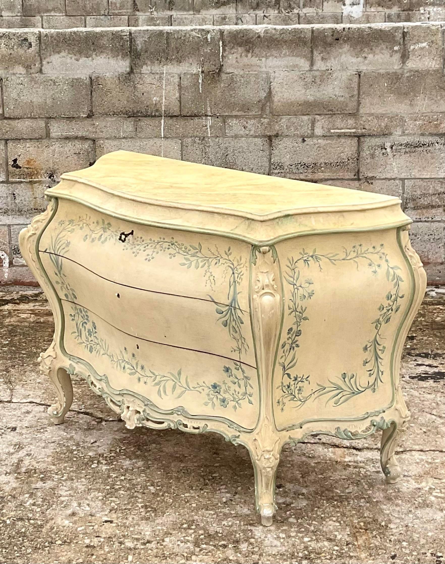 Spectacular vintage Regency hand painted commode. The height of Parisian chic in iconic blue and white. Three drawers that open with a key and beautiful ring of floating flowers. Hand carved detail. Acquired from a Palm Beach estate.