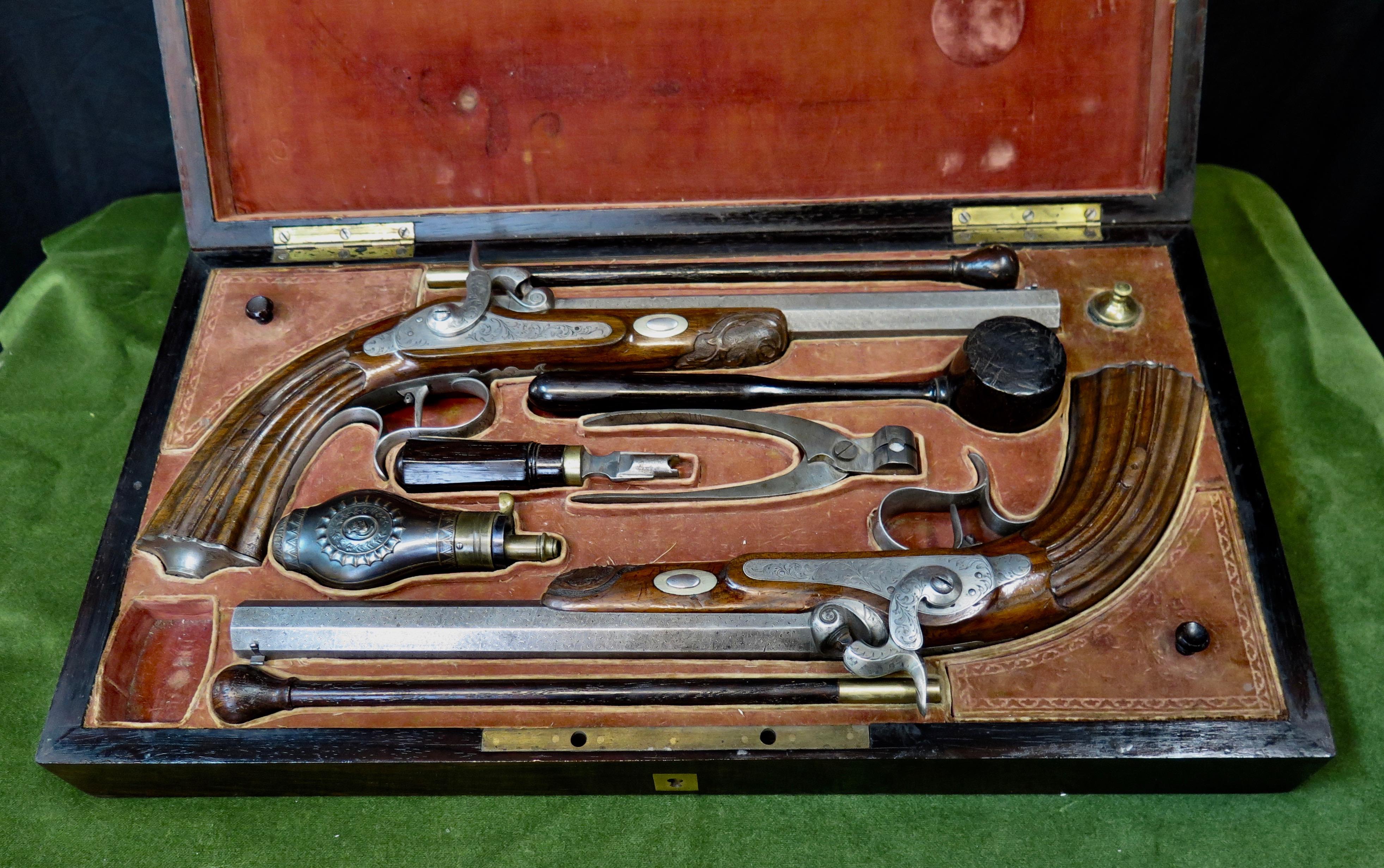 These vintage early to mid-19th century French percussion cap dueling pistols are presented in their original carrying case. Each is beautifully designed with a decorative etched elongated steel octagon shape barrel. The shaft of the barrel is