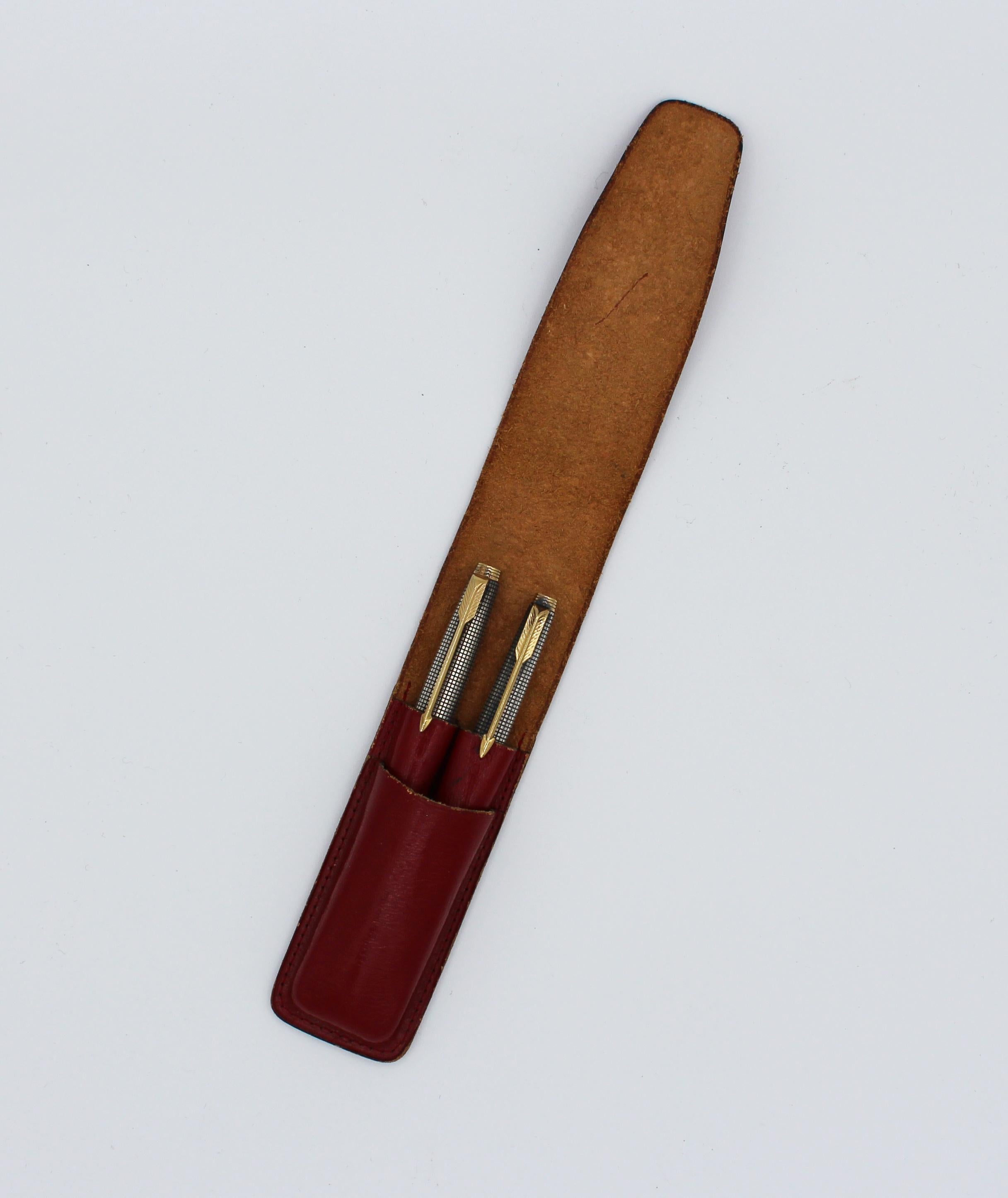 A Vintage Parker 75 Cisele sterling and gilt fountain pen and pencil set in associated red leather case; 14k gold XF nib marked Parker, 14k Point, USA. Pencil also marked sterling silver, Parker, Made in USA. Pencil insert lacking. Sold from estate