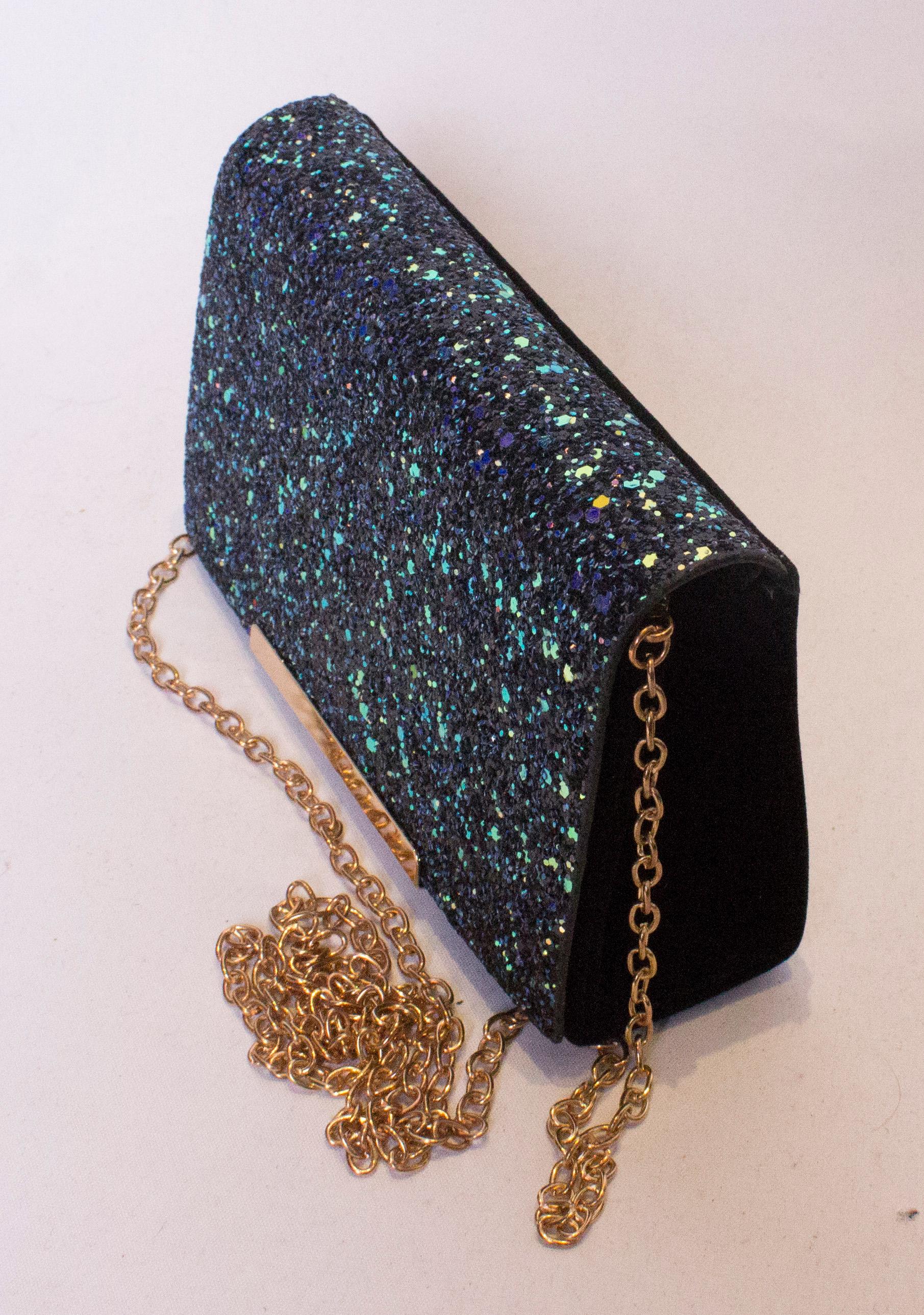 A great bag for the party season. In a pretty mix of blue ,lilac, pink and green. The bag has a flap over front, with a popper fastening . Internally there is one pouch pocket and a detachable gold chain , so the it can be worn as a clutch or a