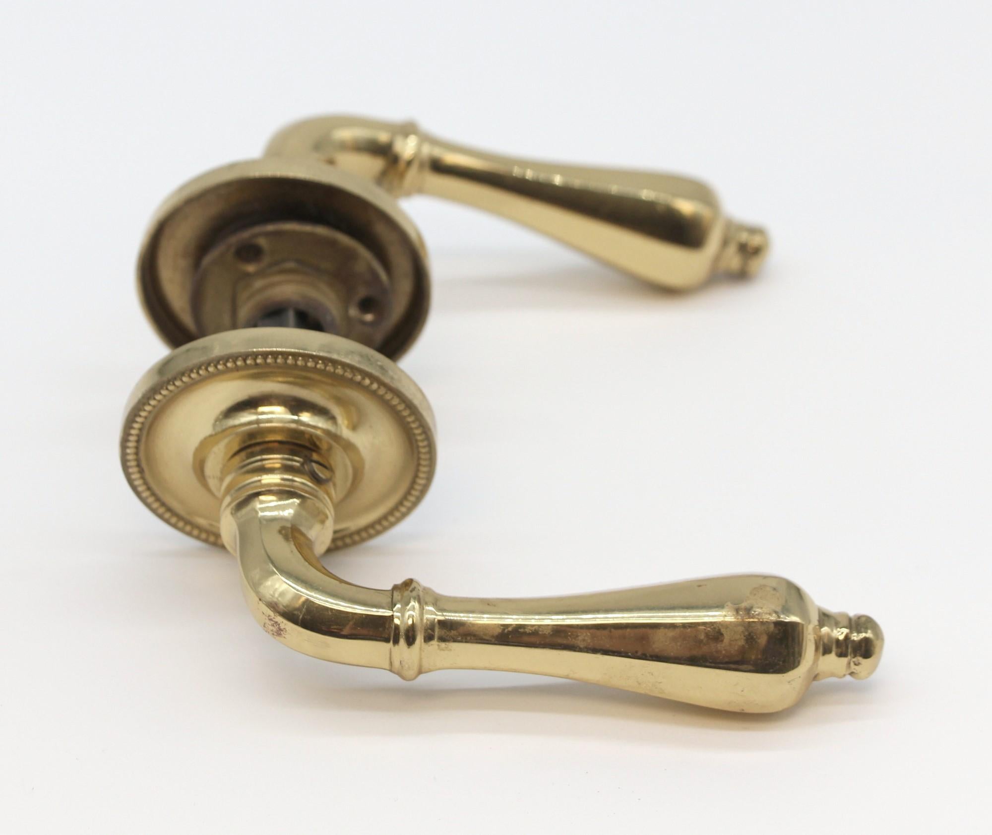 Polished brass vintage passage lever door knob set. Set includes two knobs, a spindle and two rosettes. Priced per set. Small quantity available at time of posting. Please inquire. Please note, this item is located in our Scranton, PA location.